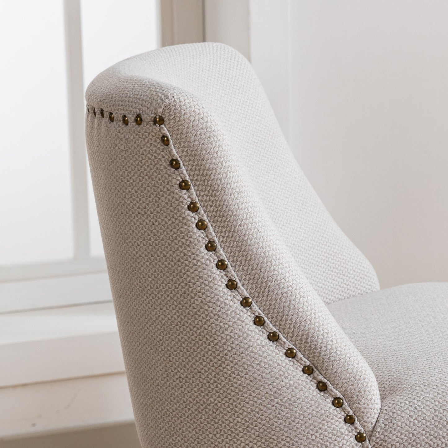 Cream textured armchair with antique brass nailhead trim detailing