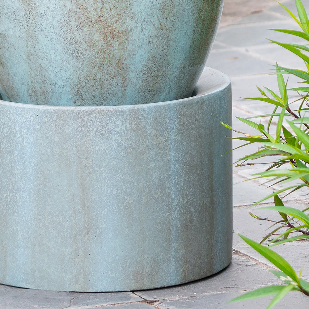 Textured concrete planter with a weathered teal patina ideal for outdoor gardens