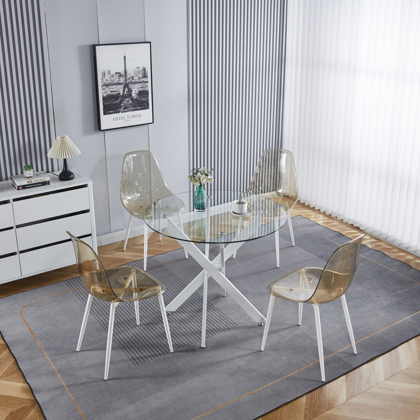 Glass top dining table with white Xframe base and four translucent amber chairs