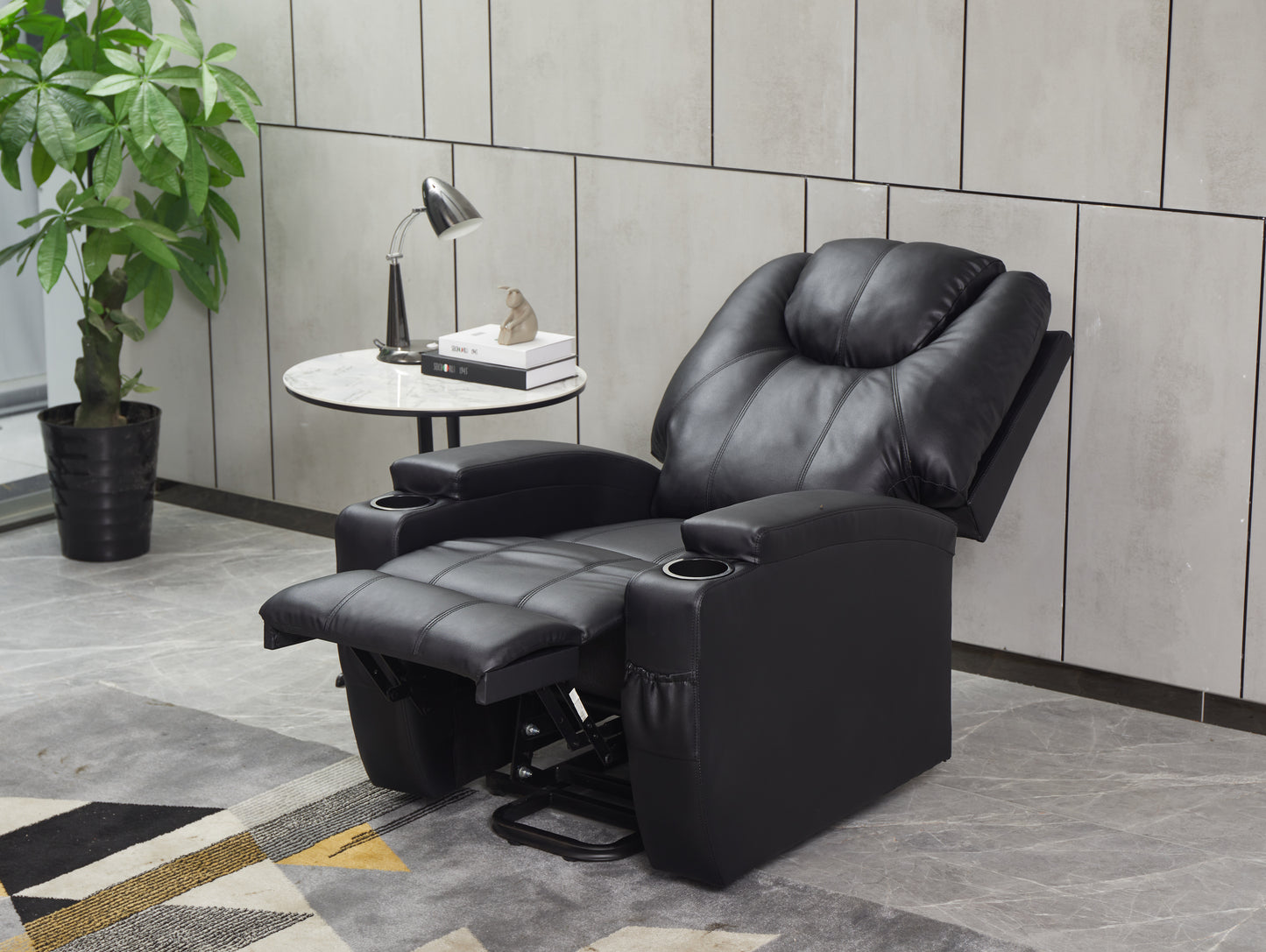Black leather recliner chair with footrest extended and cup holders ideal for home theaters