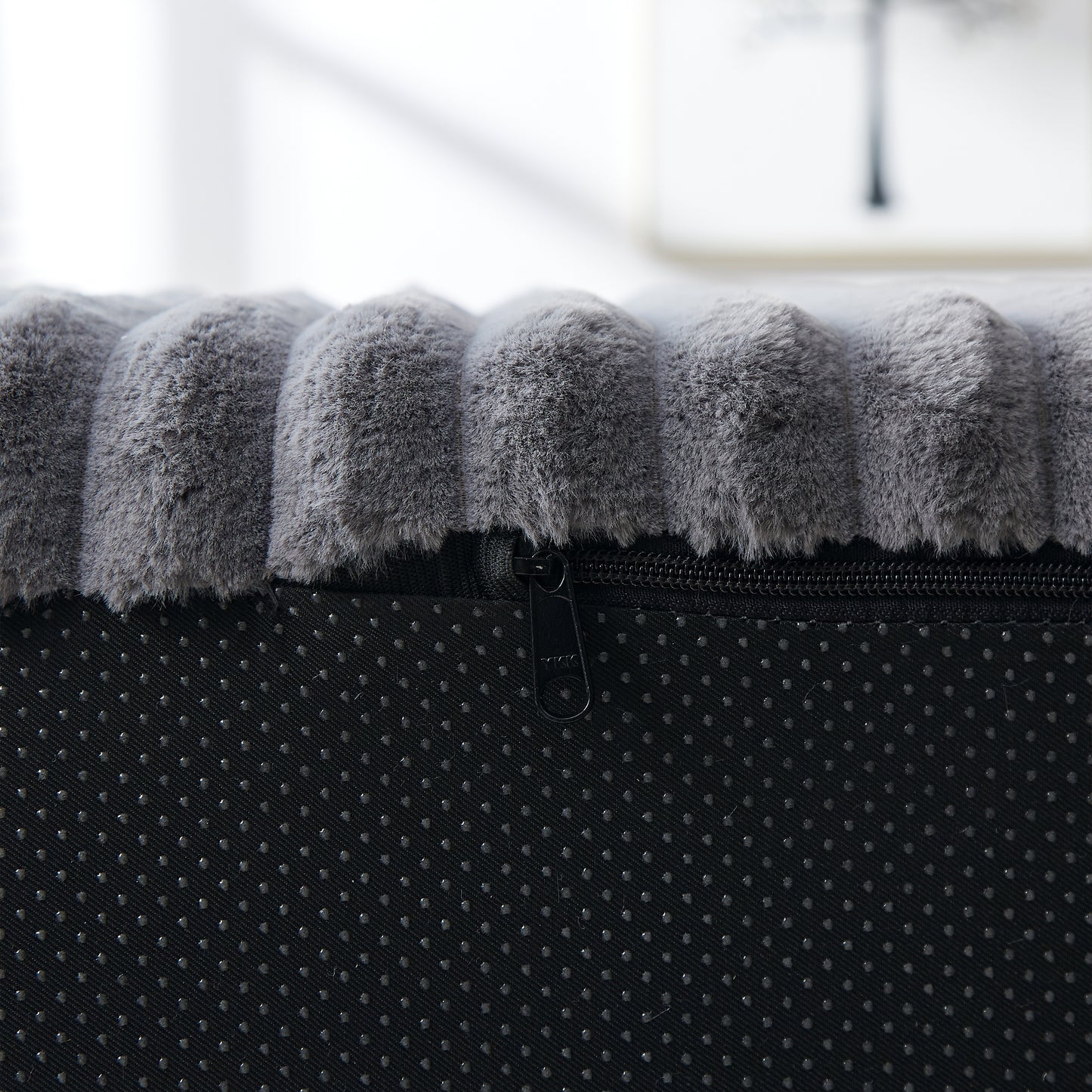 Plush grey dog bed with textured surface and zipper detail