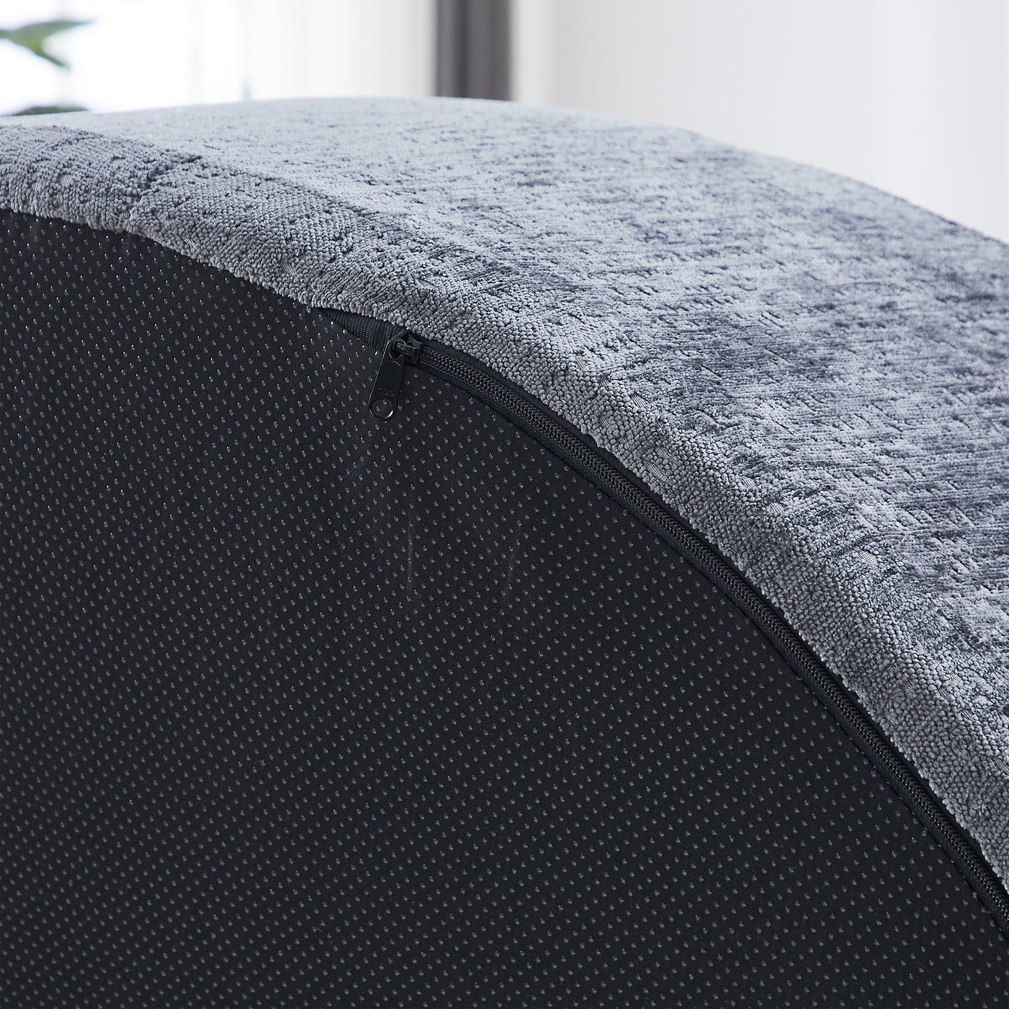 Closeup of textured grey fabric with a visible black zipper closure on a nonslip matting