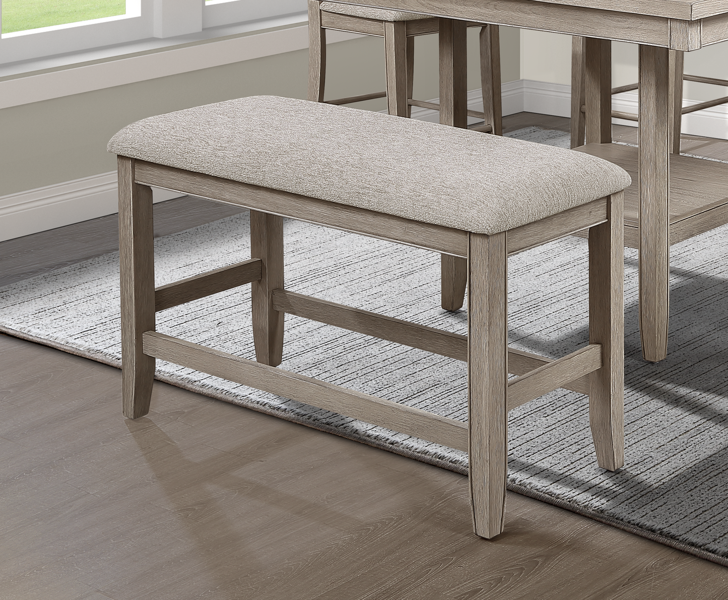 Light brown fabric upholstered counter stool with a distressed wood frame and slender legs