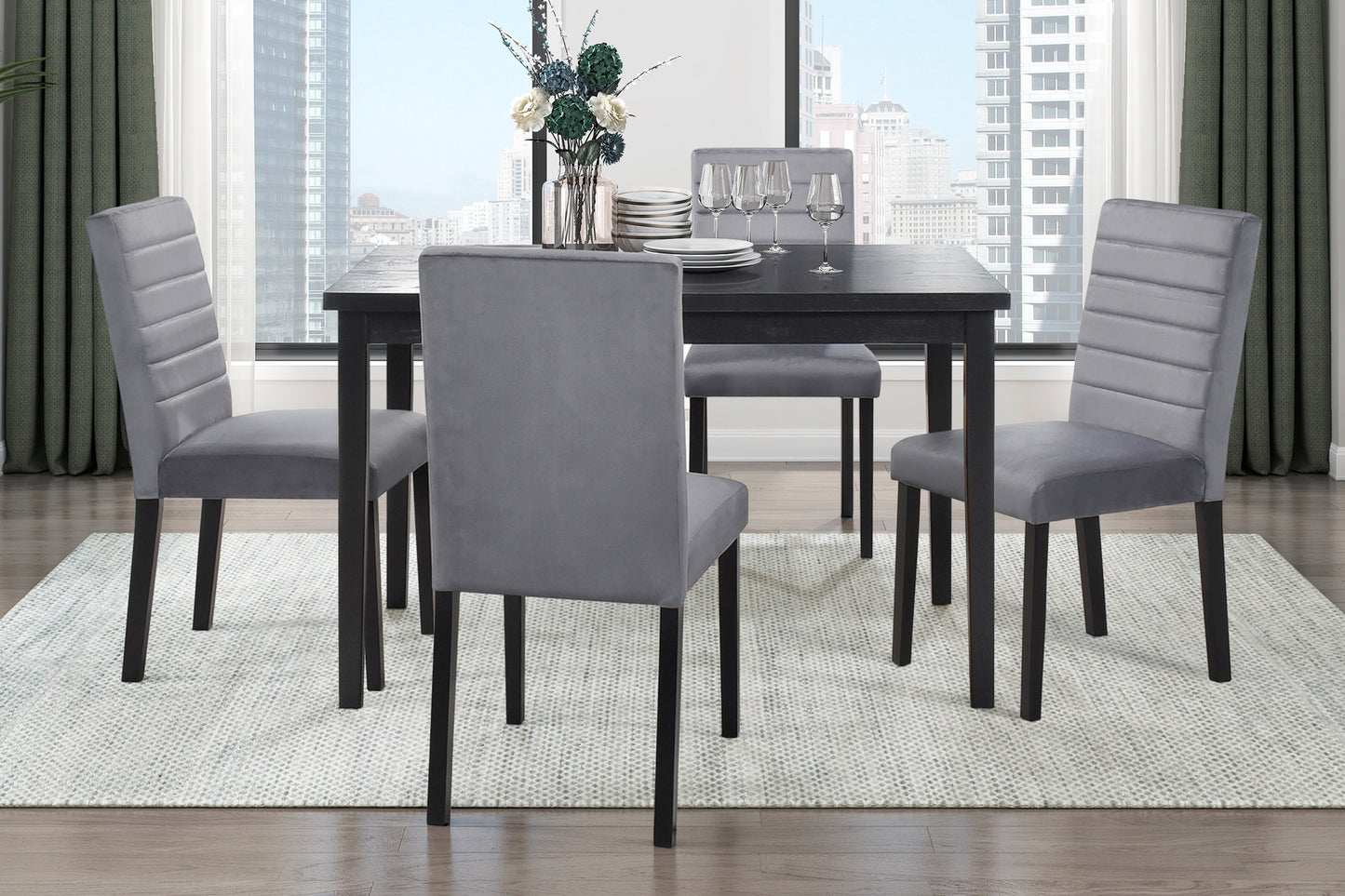 Four plush grey dining chairs surround a dark wood table with place settings and floral arrangement