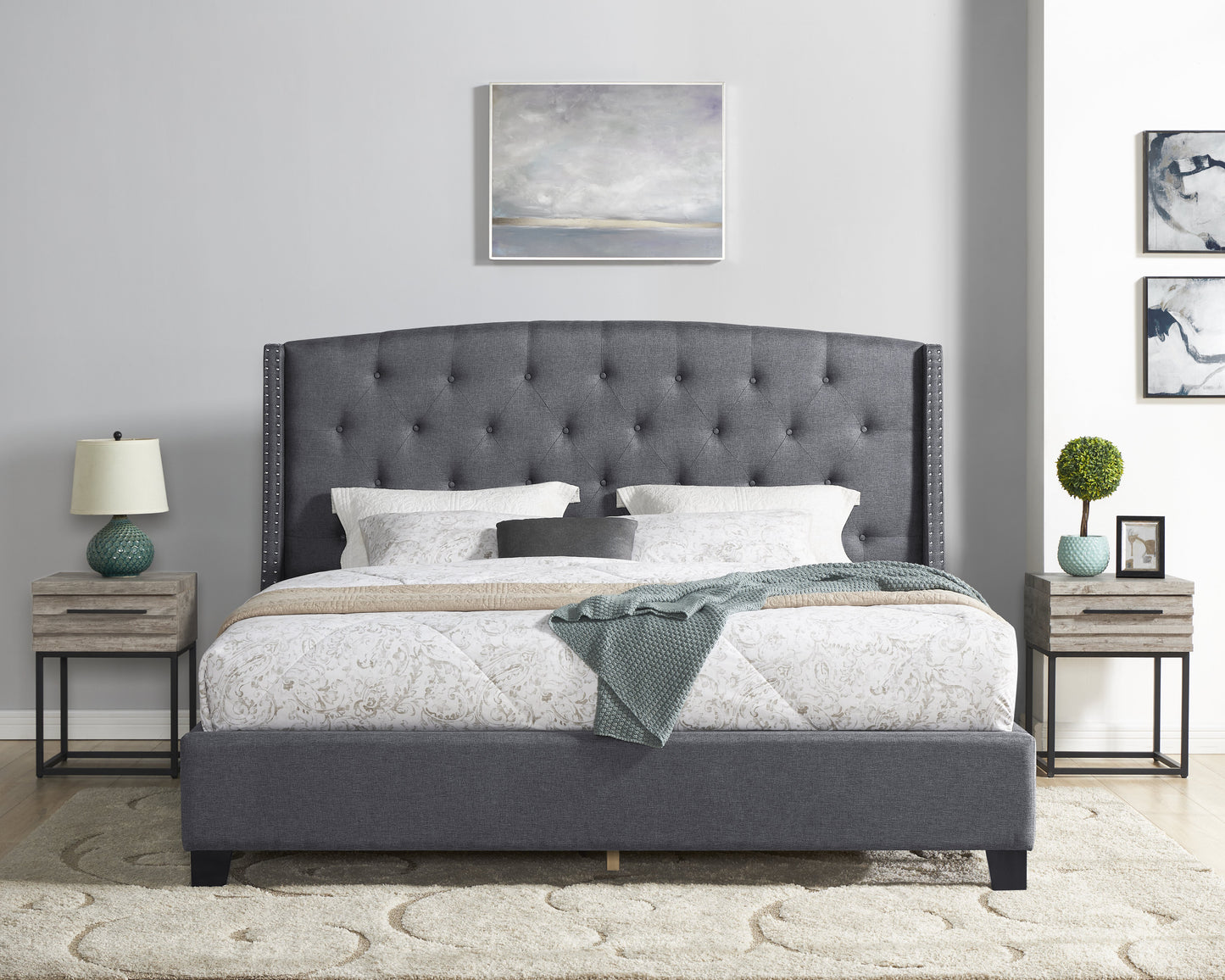 Dark gray upholstered platform bed with diamond tufting and silver nailhead trim