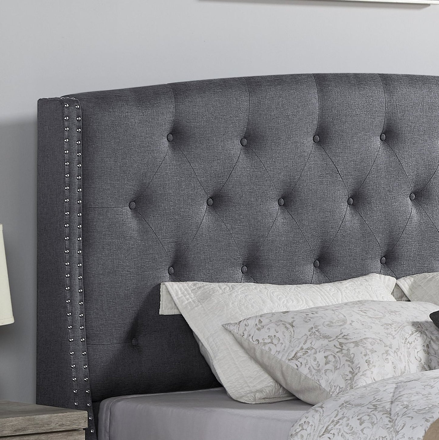 Dark gray tufted upholstered king headboard with silver nailhead trim