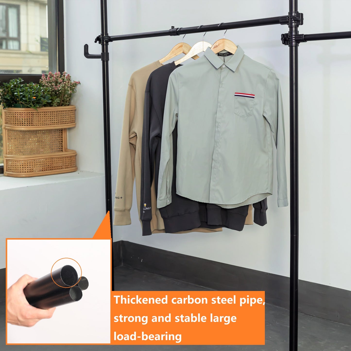 Black industrial garment rack with three layered clothing items