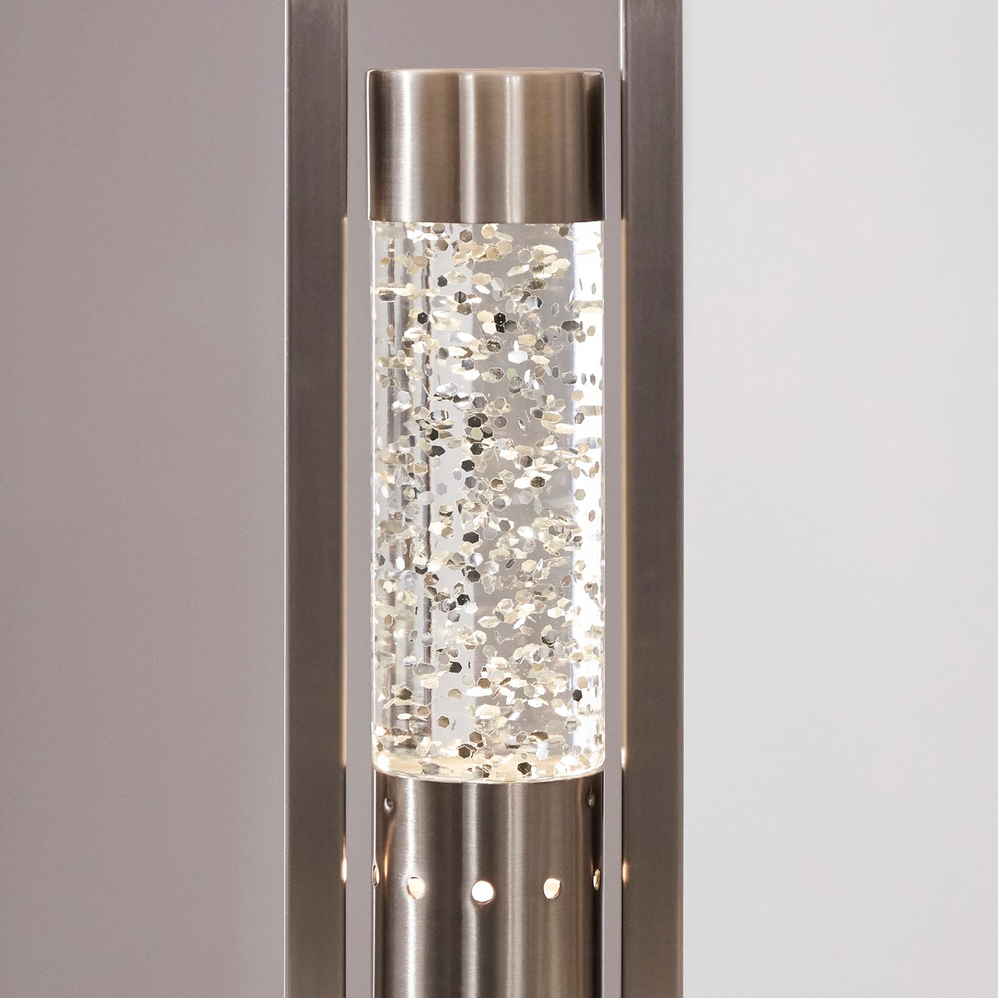 Sleek brushed nickel floor lamp with clear glass cylinder filled with shimmering gold glitter for ambient light