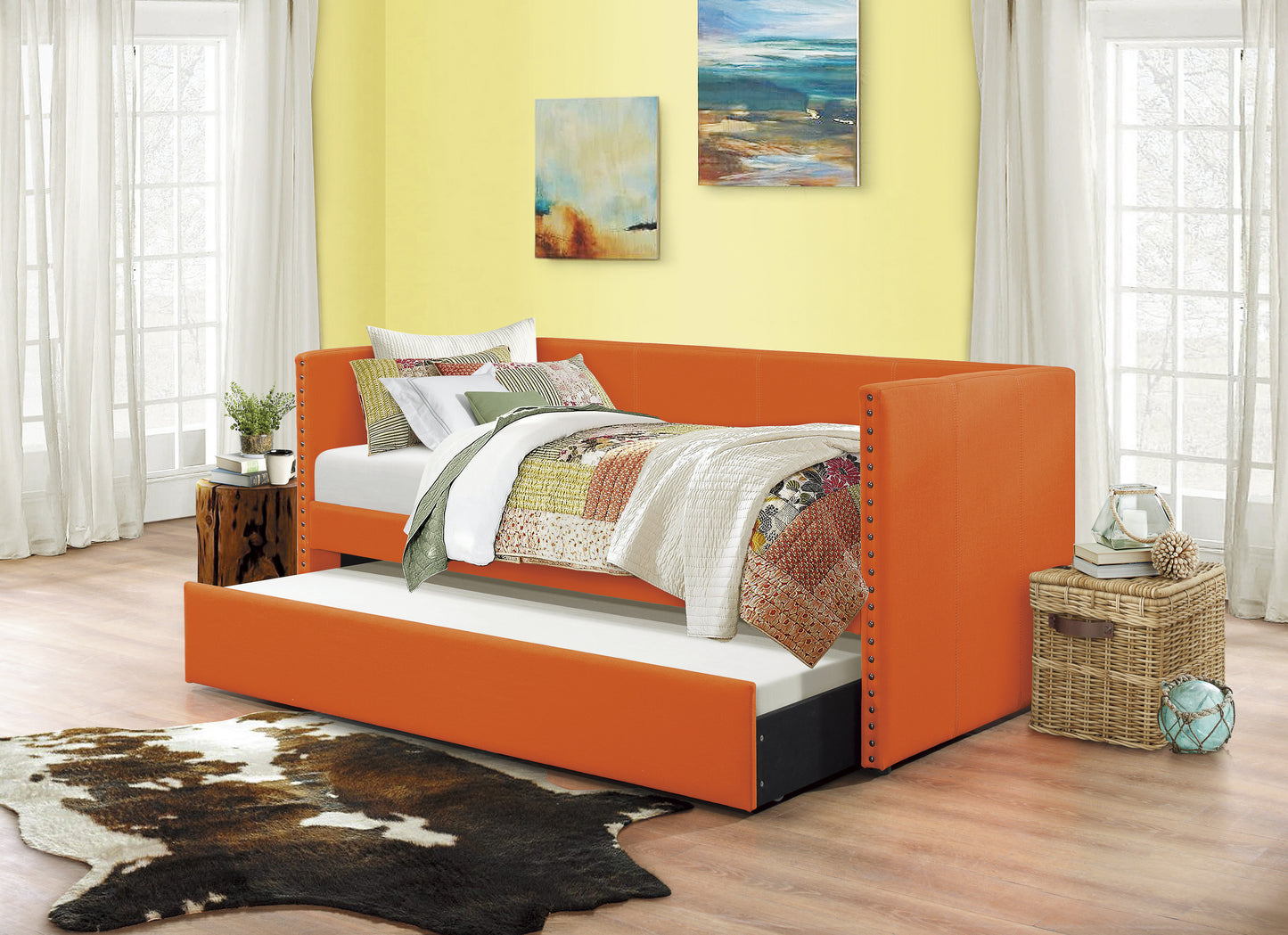Orange upholstered daybed with a trundle bed and studded armrests perfect for guest rooms