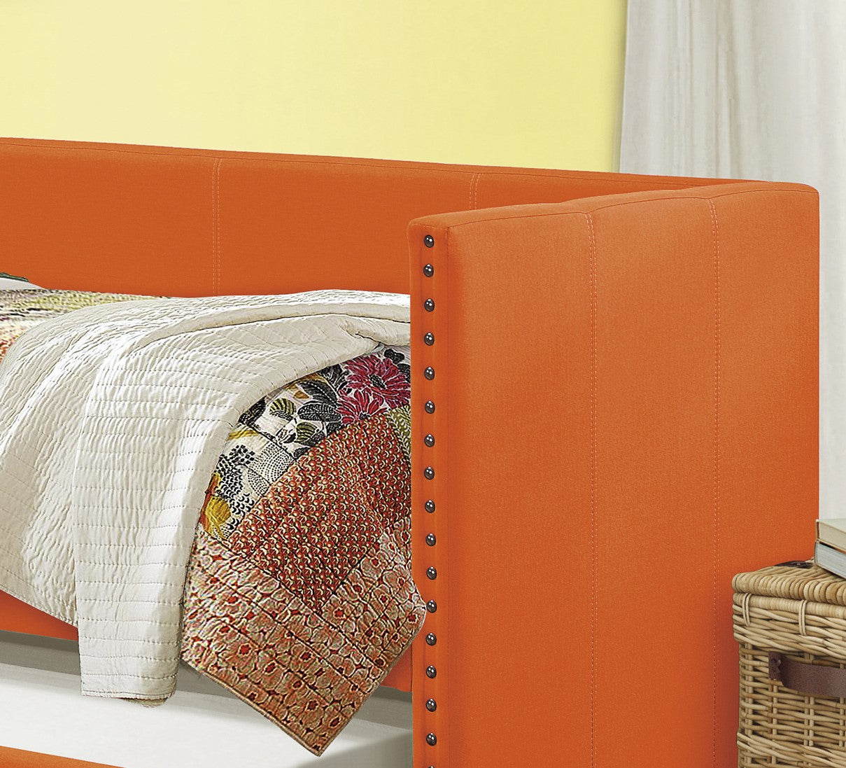 Orange upholstered bed frame with nailhead trim detail and a quilted white duvet