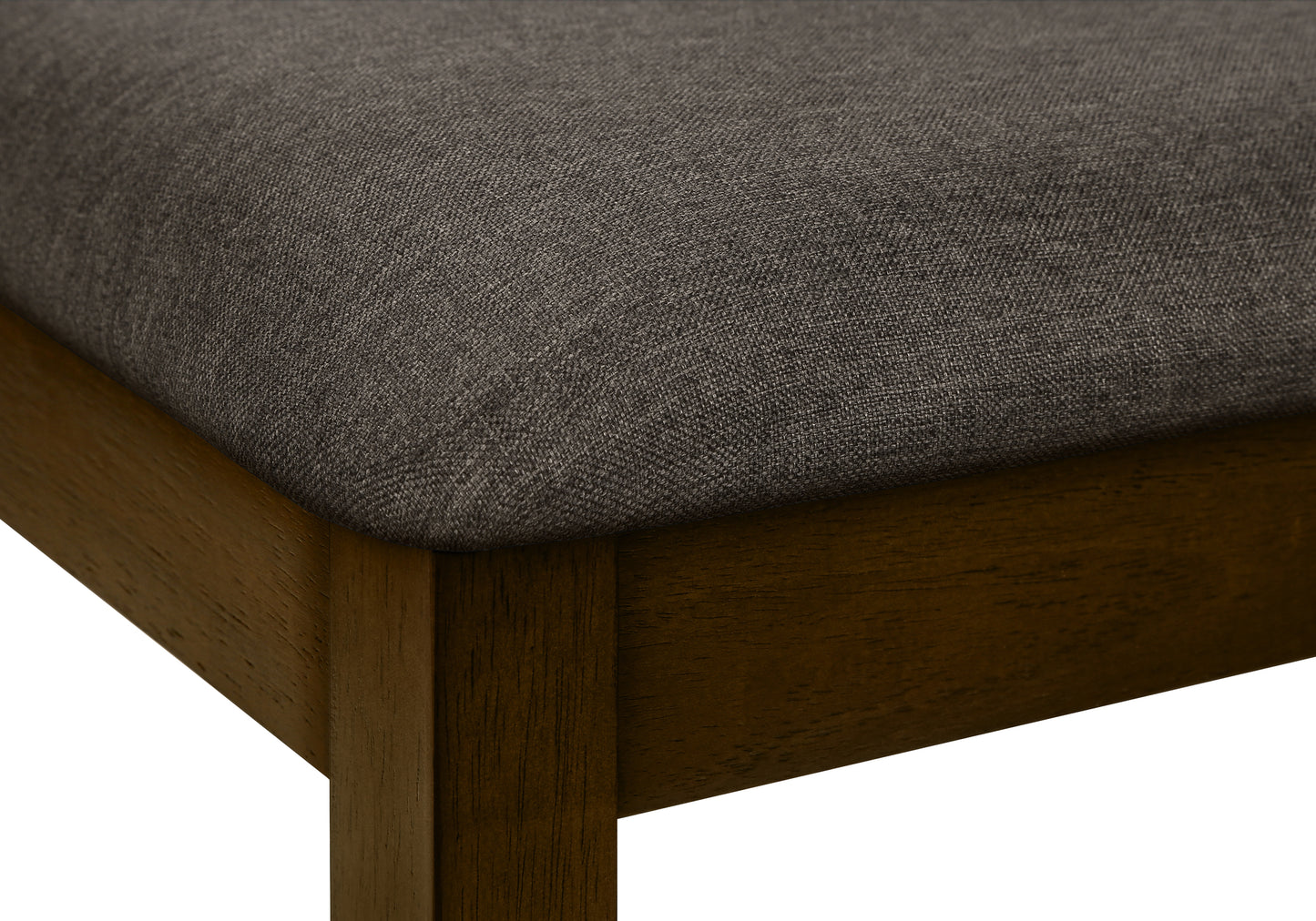 Closeup of a dark grey upholstered seat on a dark wood dining chair leg