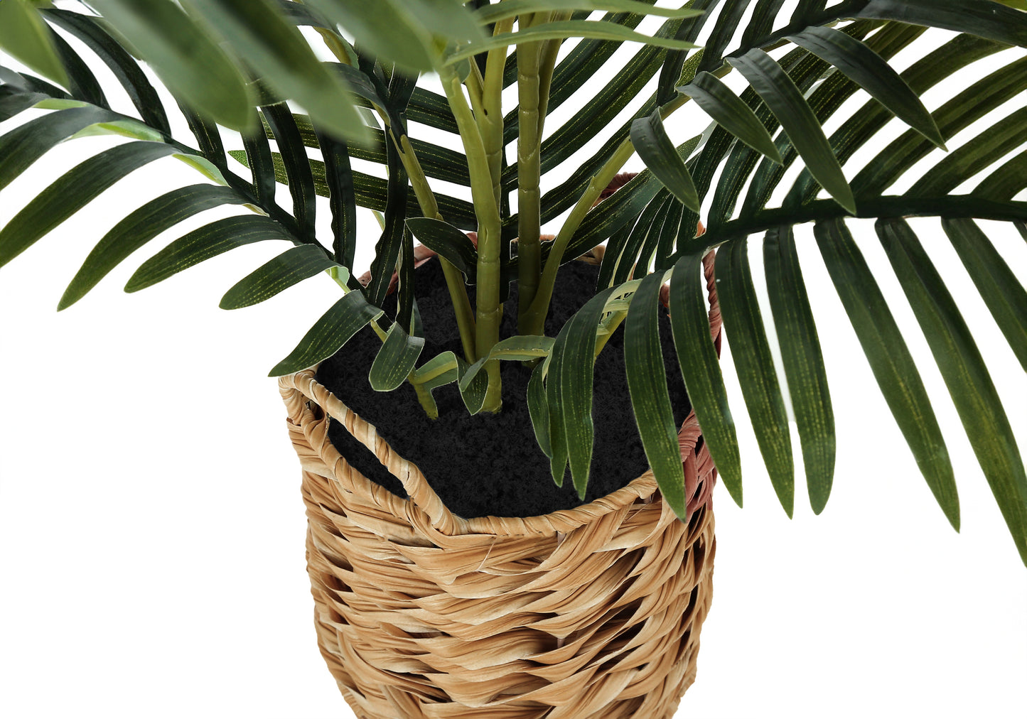 Closeup of a green faux palm plant in a woven basket planter adding tropical decor