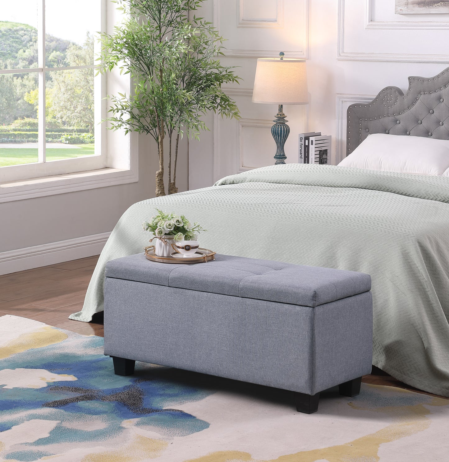 Tufted grey linen storage ottoman with dark legs