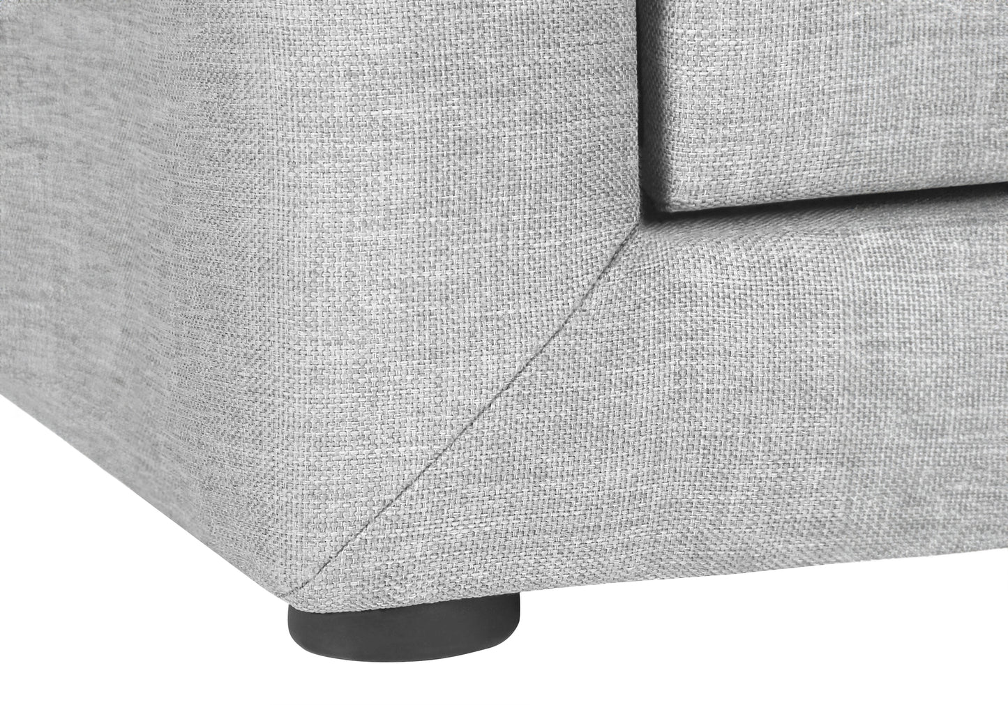 Closeup of light grey textured fabric sofa corner with a black wooden leg