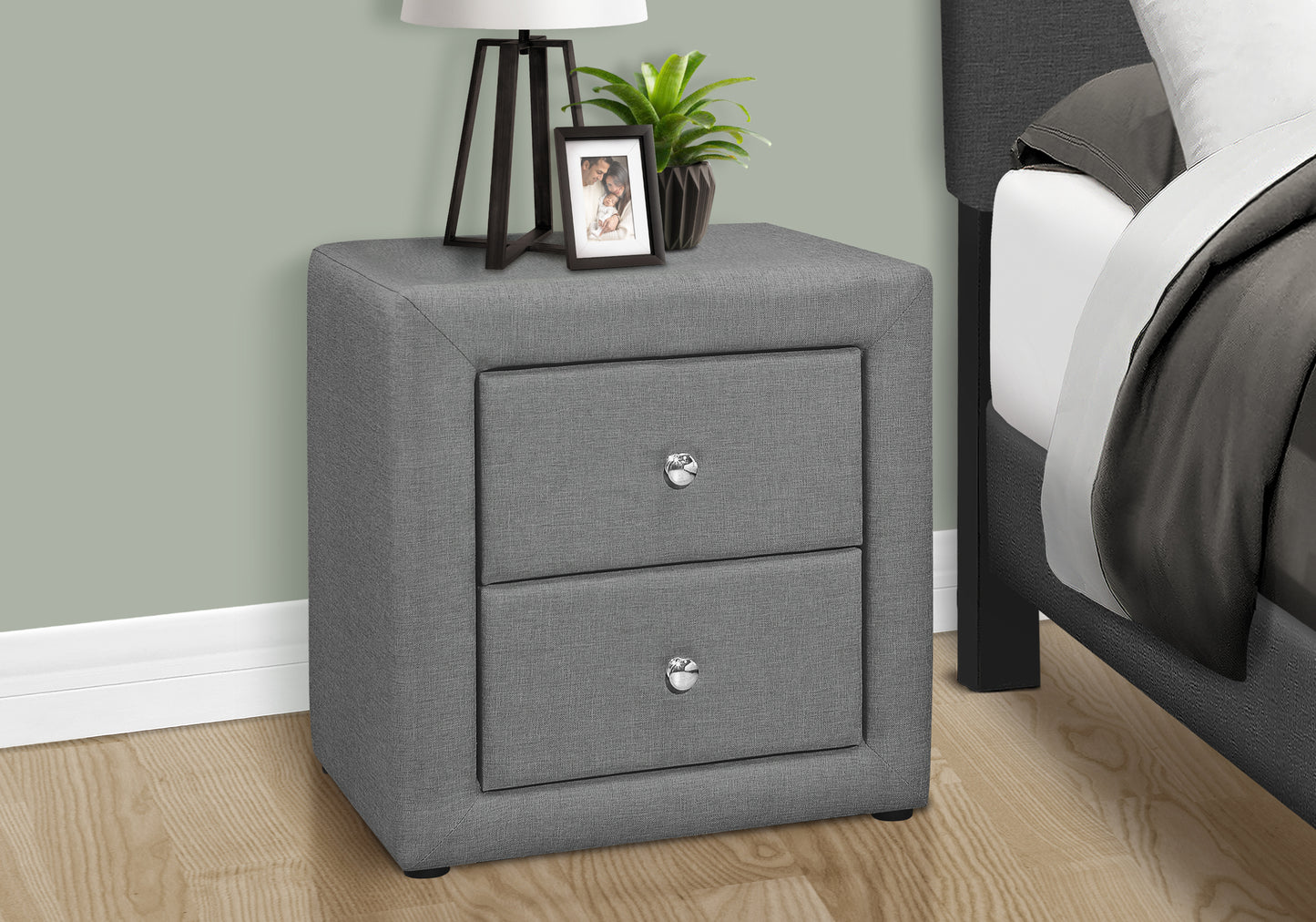 Gray fabric upholstered nightstand with two drawers and chrome knobs