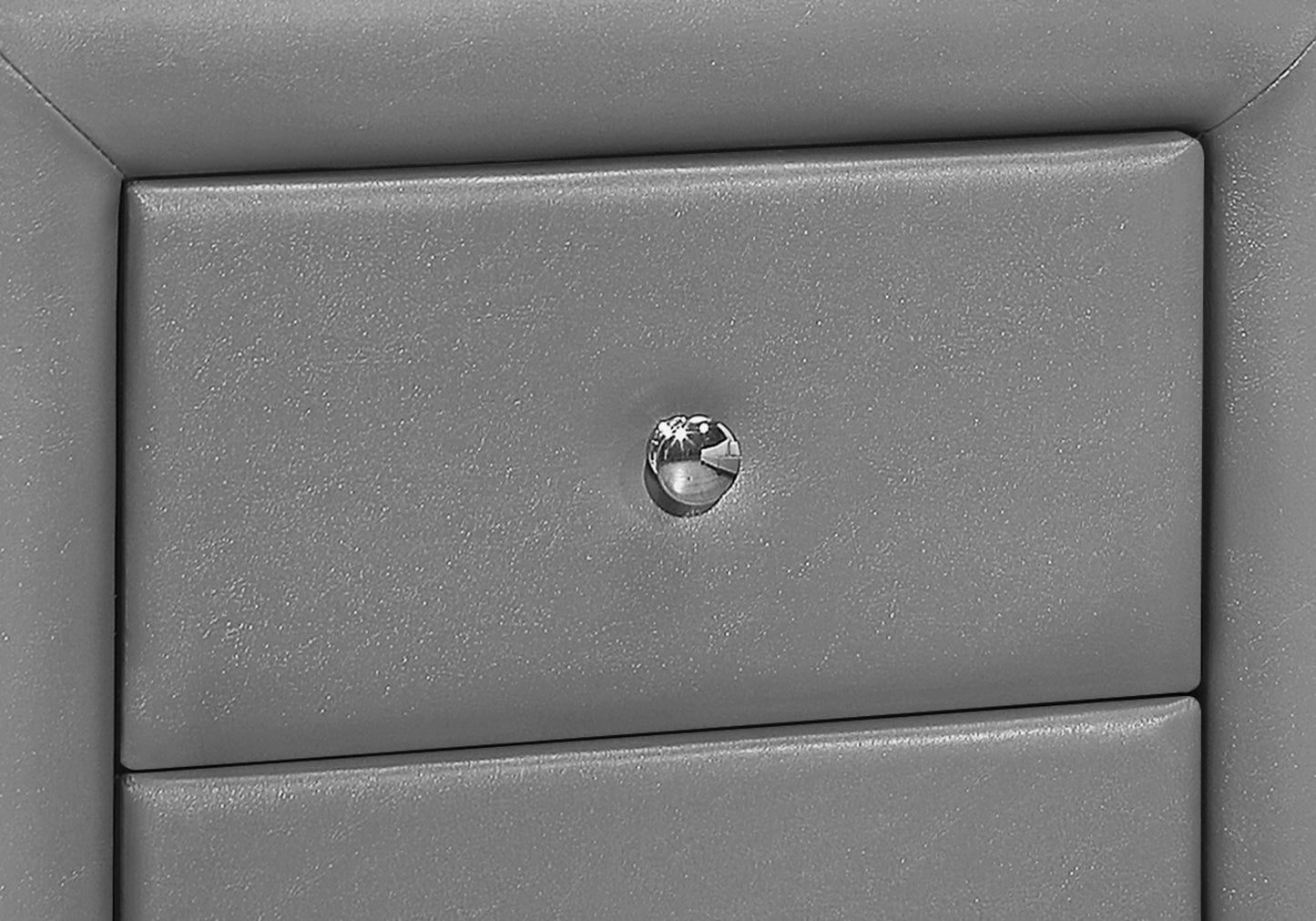 Closeup of gray faux leather nightstand drawer with a crystal knob modern design