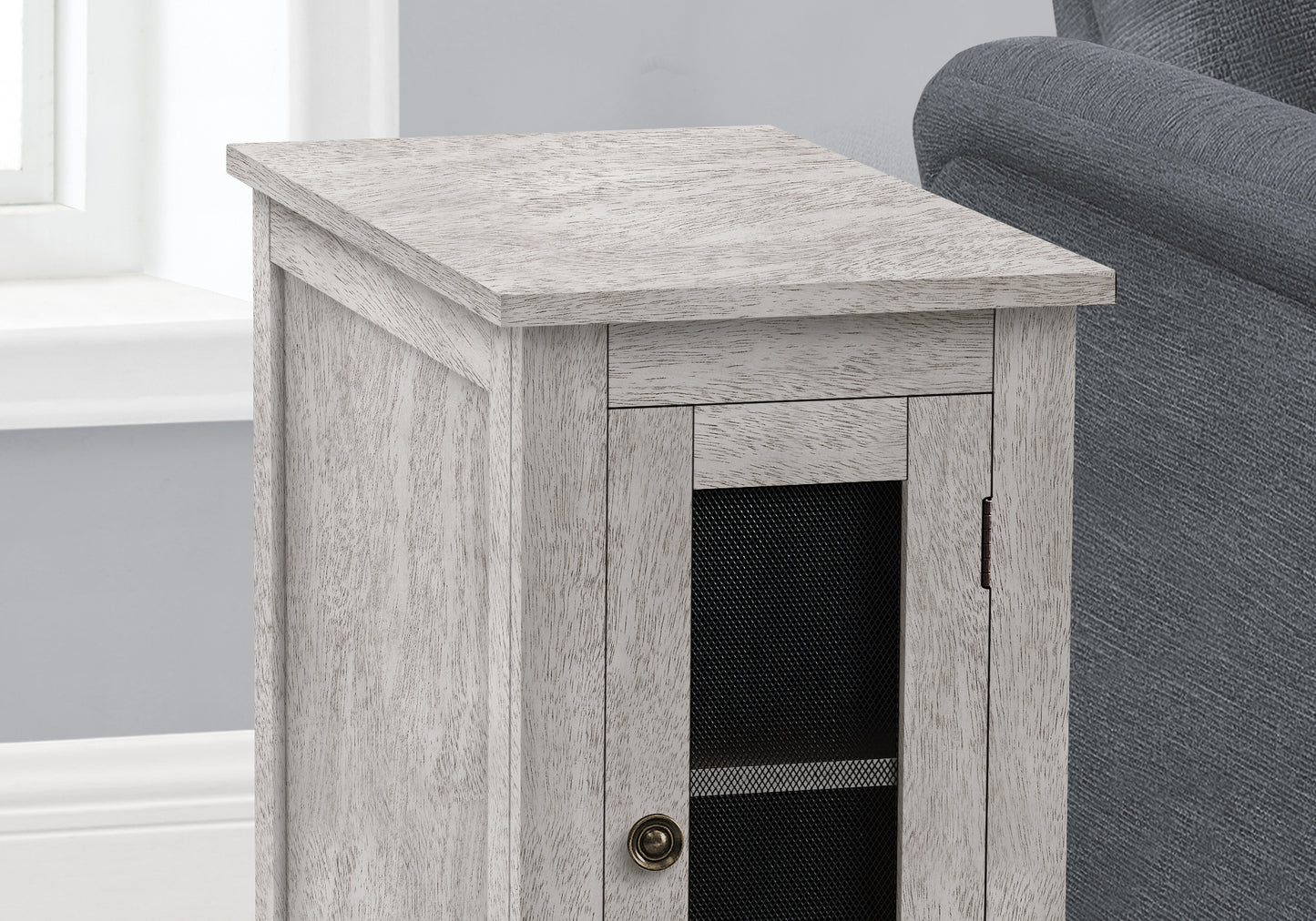 Distressed white wood accent cabinet with a single mesh door and antique brass knob
