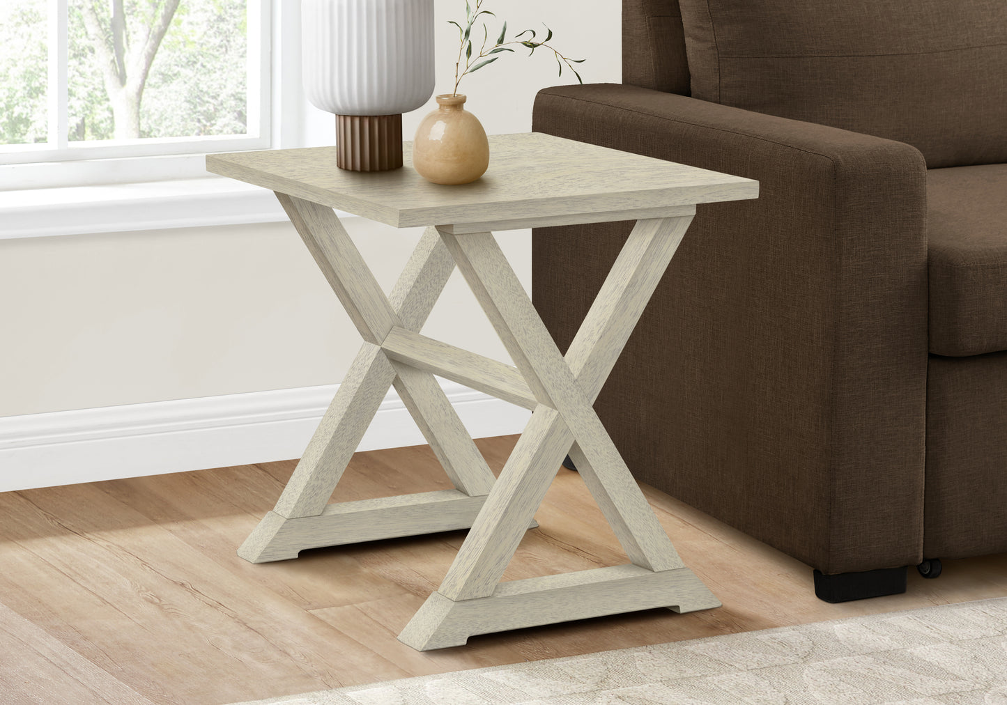 Light oak weathered wood accent table with cross base near sofa