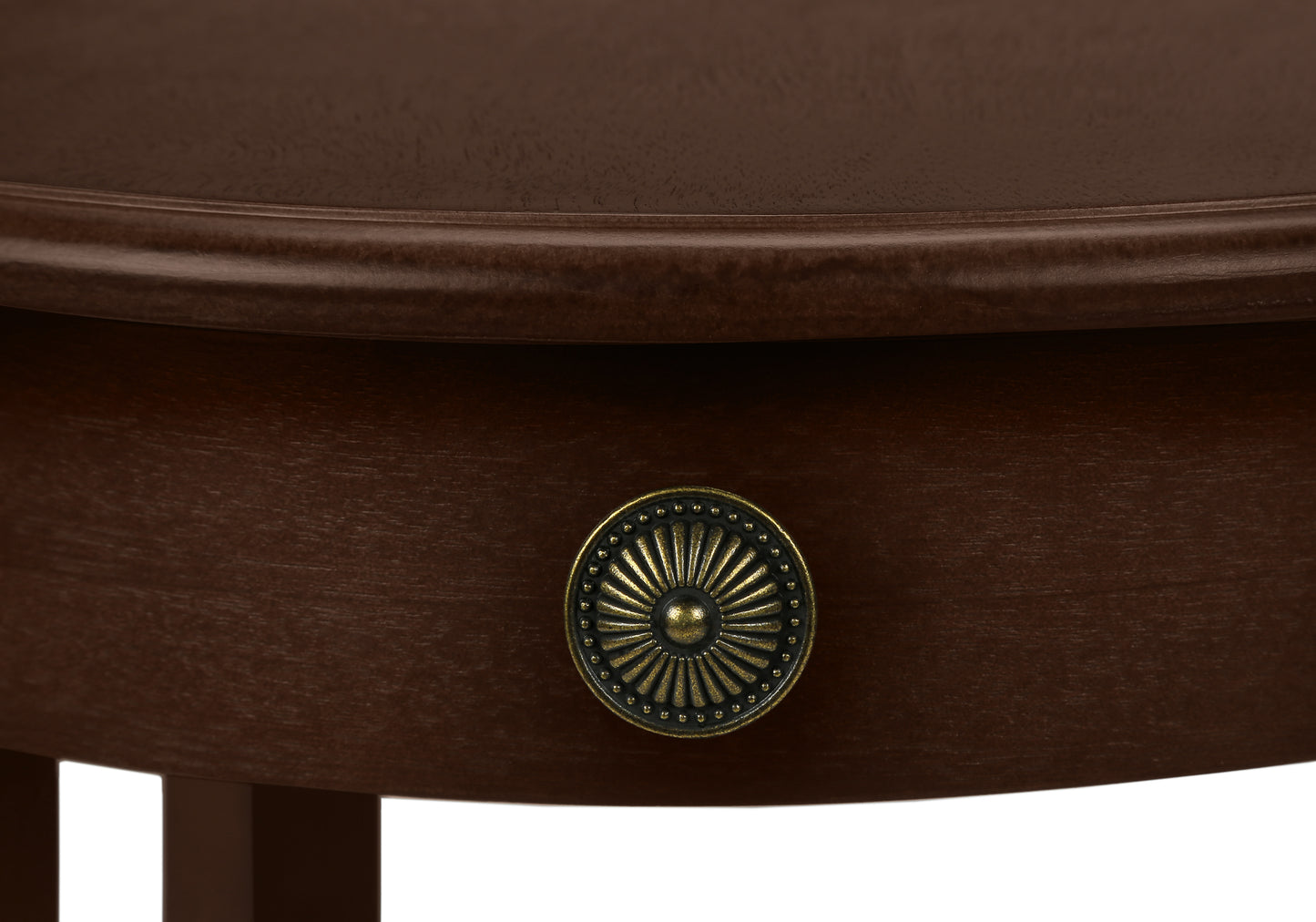 Antique brass sunburst drawer pull on a dark wood bedside table