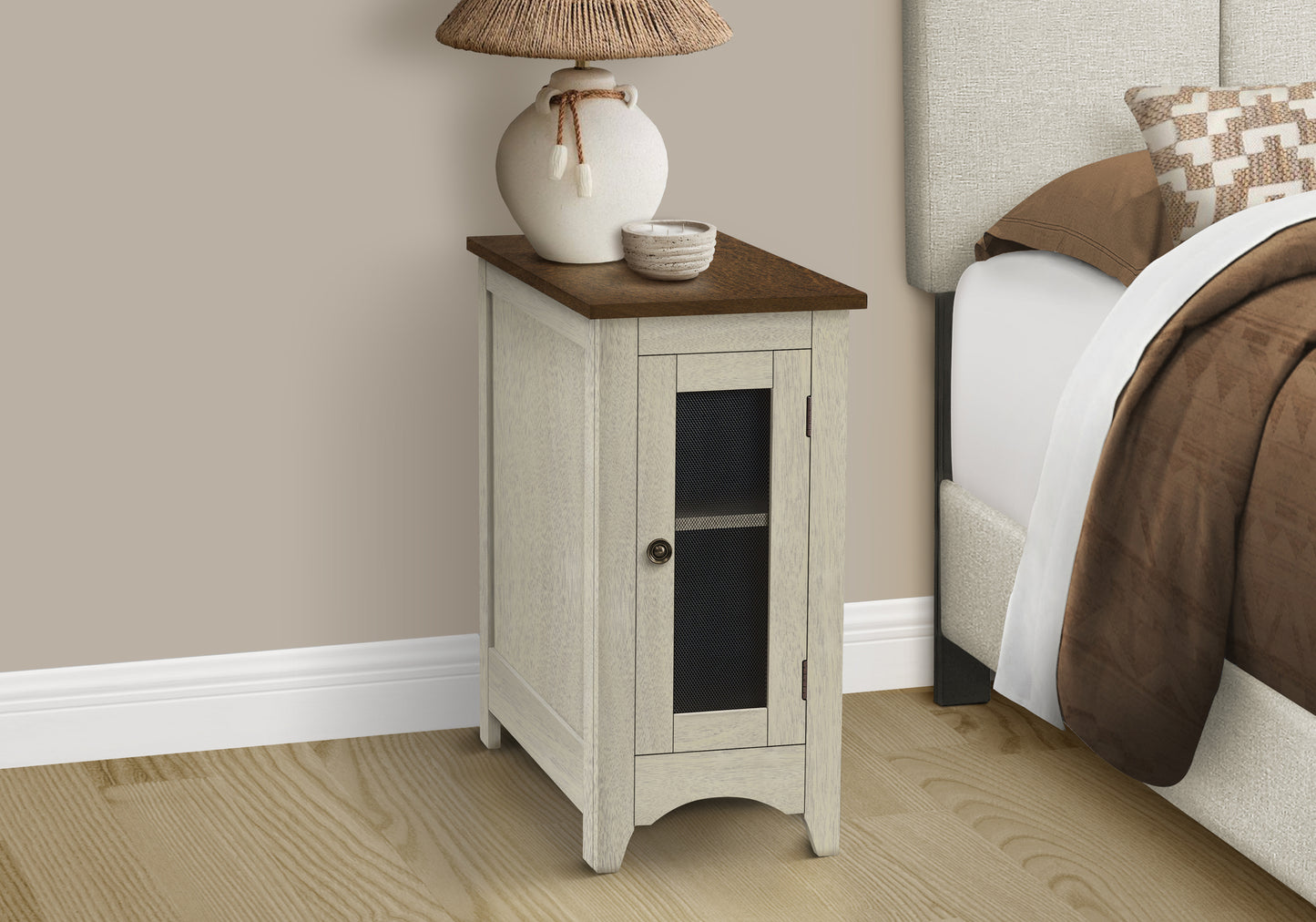 Tall narrow bedside table with a weathered white frame dark wood top and mesh cabinet door