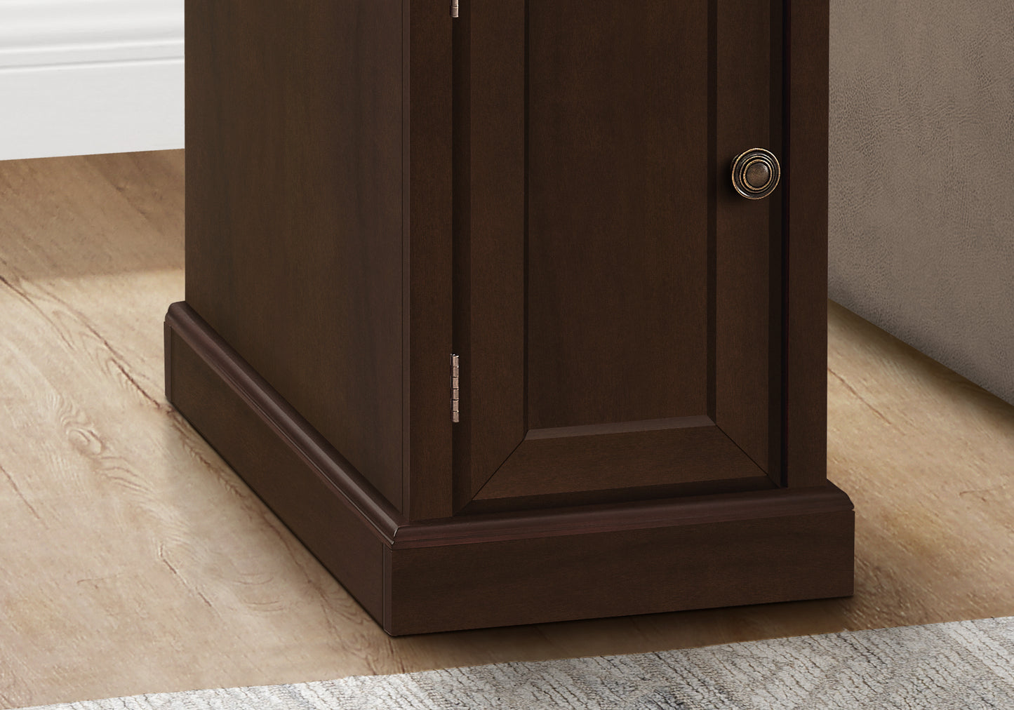 Dark brown wooden cabinet with antique brass knob and visible hinges