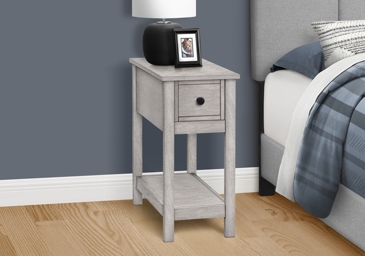 Gray wash accent table with drawer and shelf next to bed