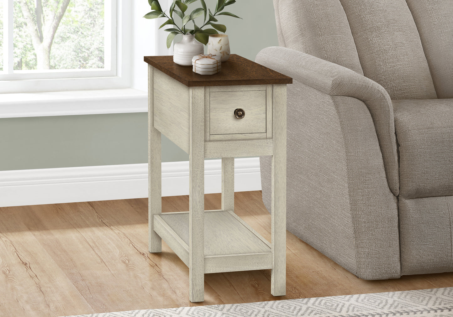 Cream and dark wood accent table with a drawer beside a textured gray recliner