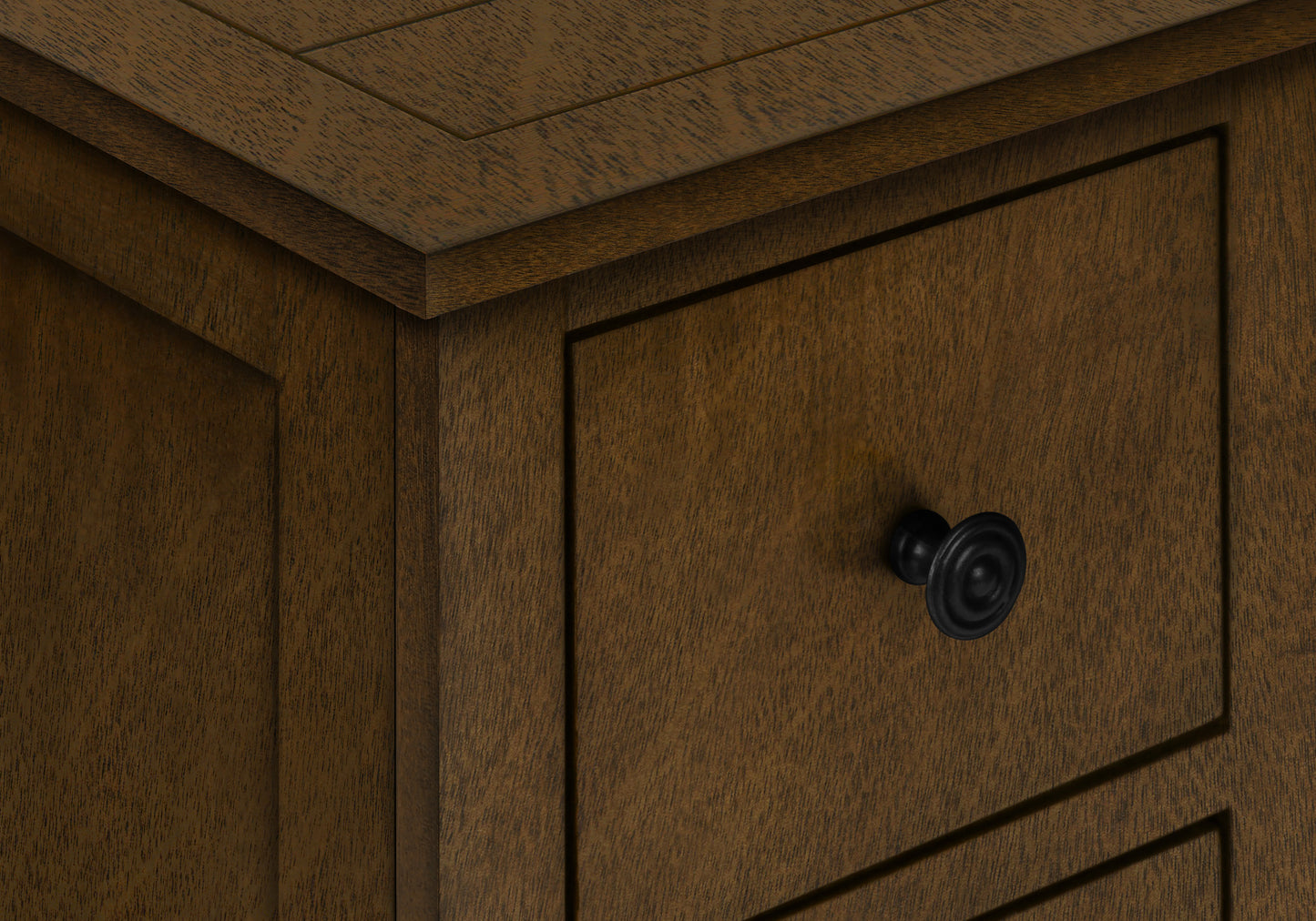 Closeup of dark brown wooden cabinet with inset drawers and black round knob