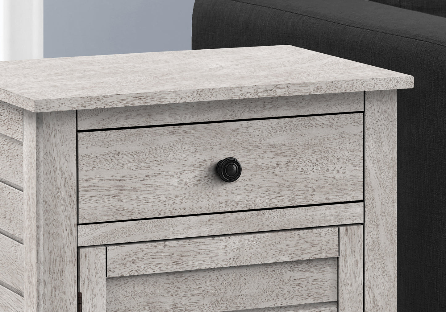 White washed wood bedside table with single black drawer pull
