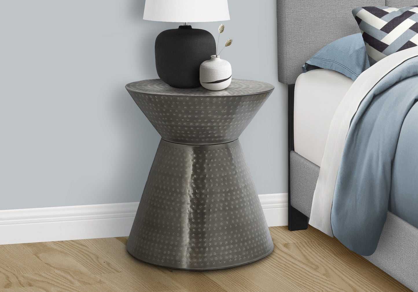 Hammered metal hourglass accent table with unique texture