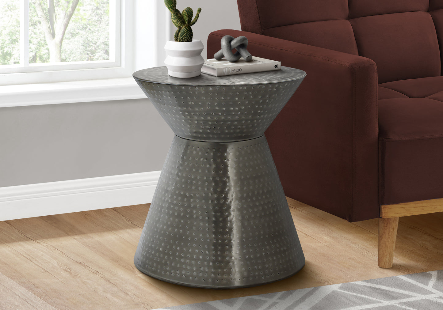 Hammered metal hourglass accent table with embossed dot pattern