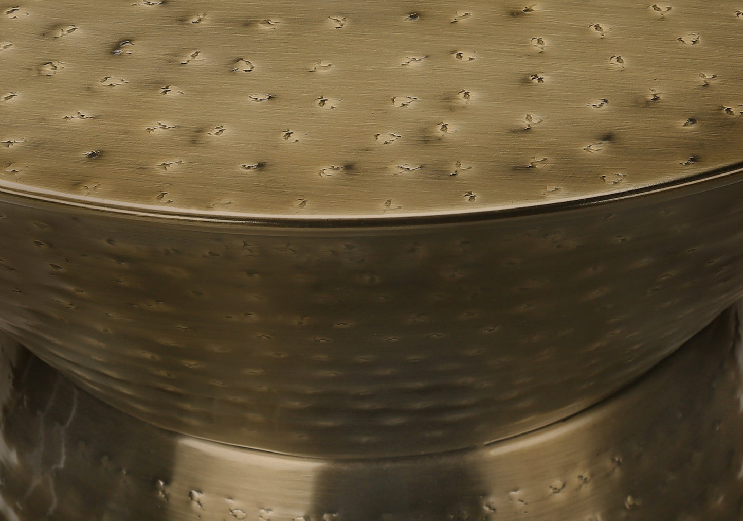 Textured brass accent table with a hammered finish and metallic sheen