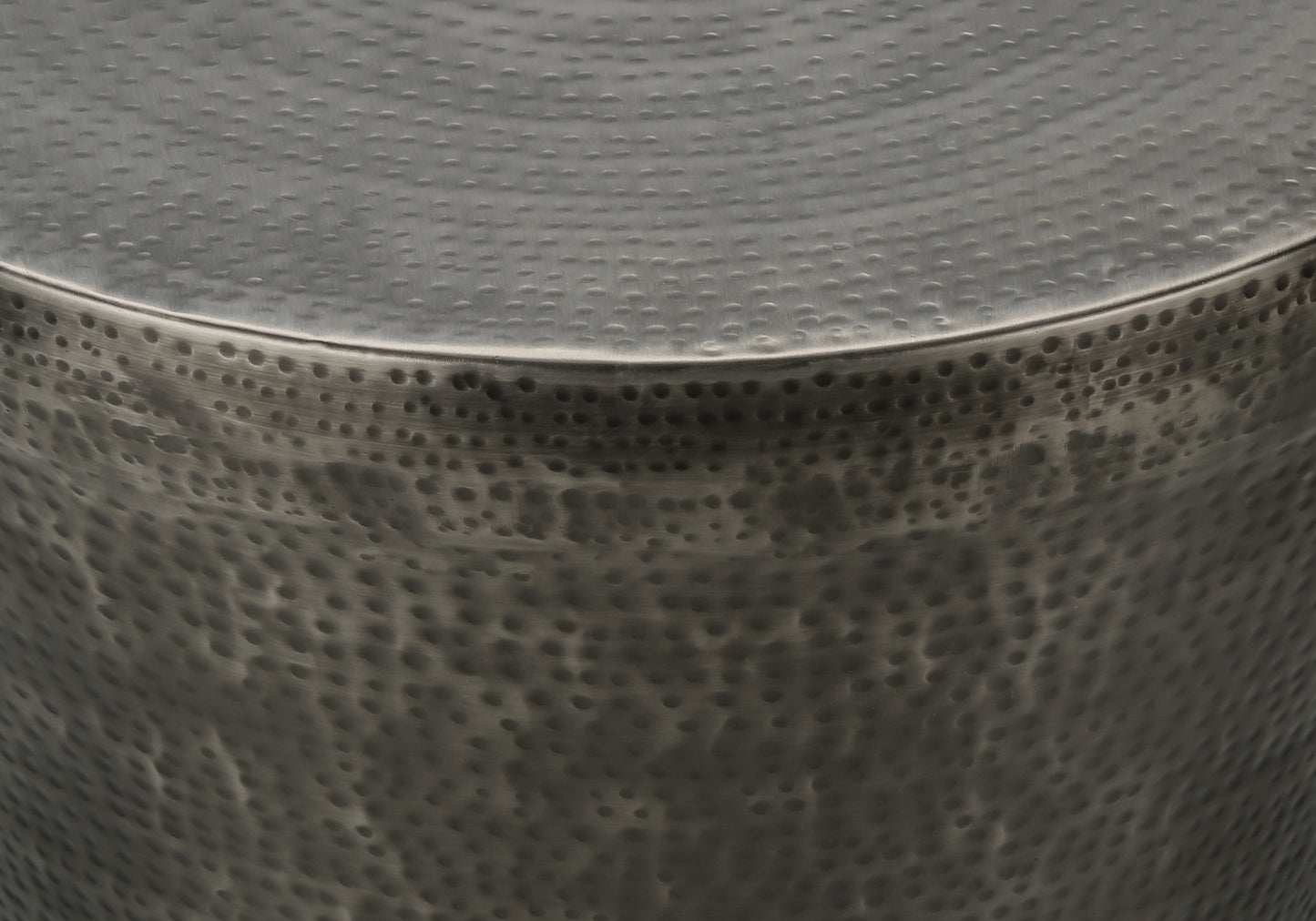 Closeup of a hammered metal side table with a silver finish