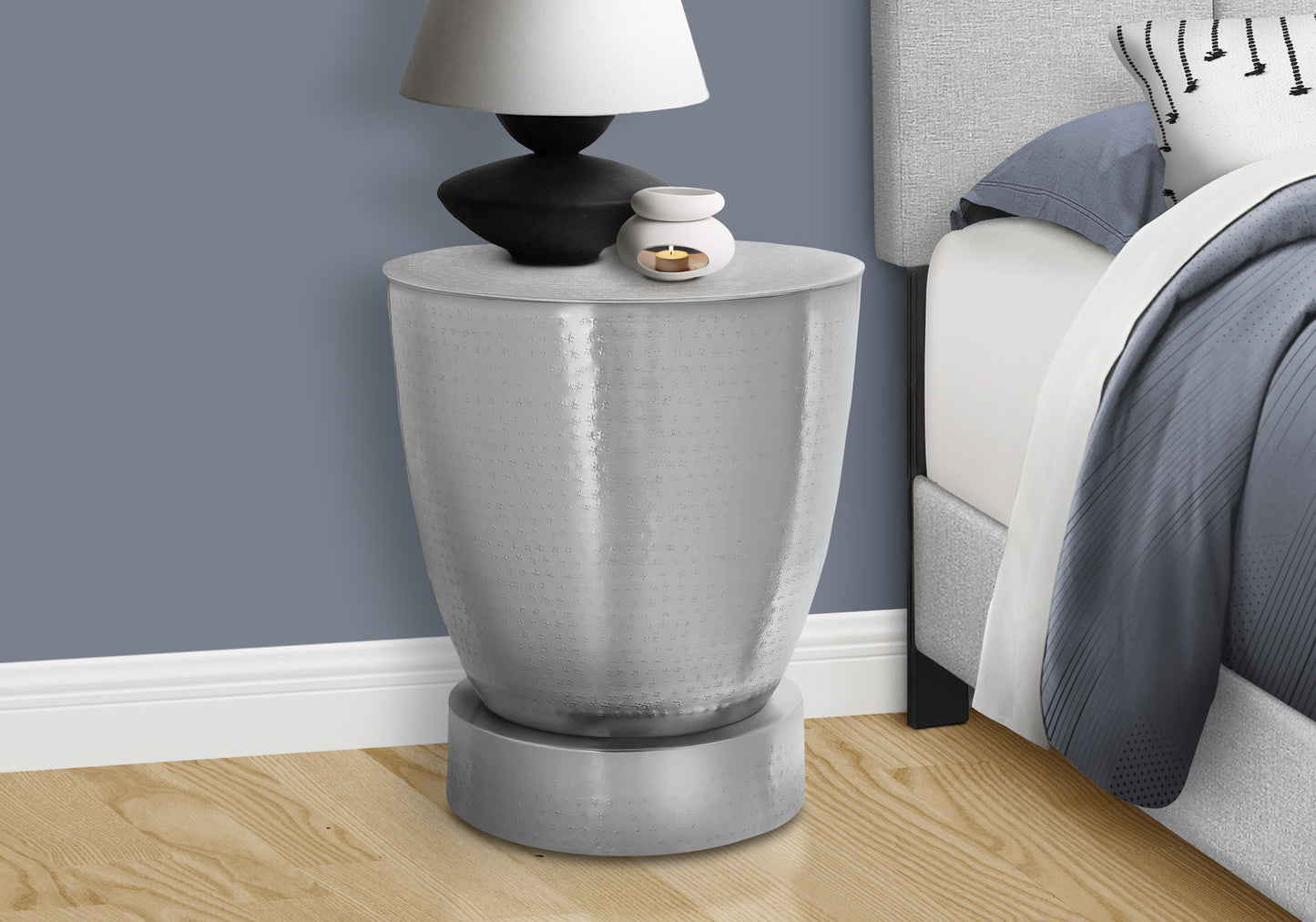Textured silver bedside table with modern design holding a lamp and oil diffuser