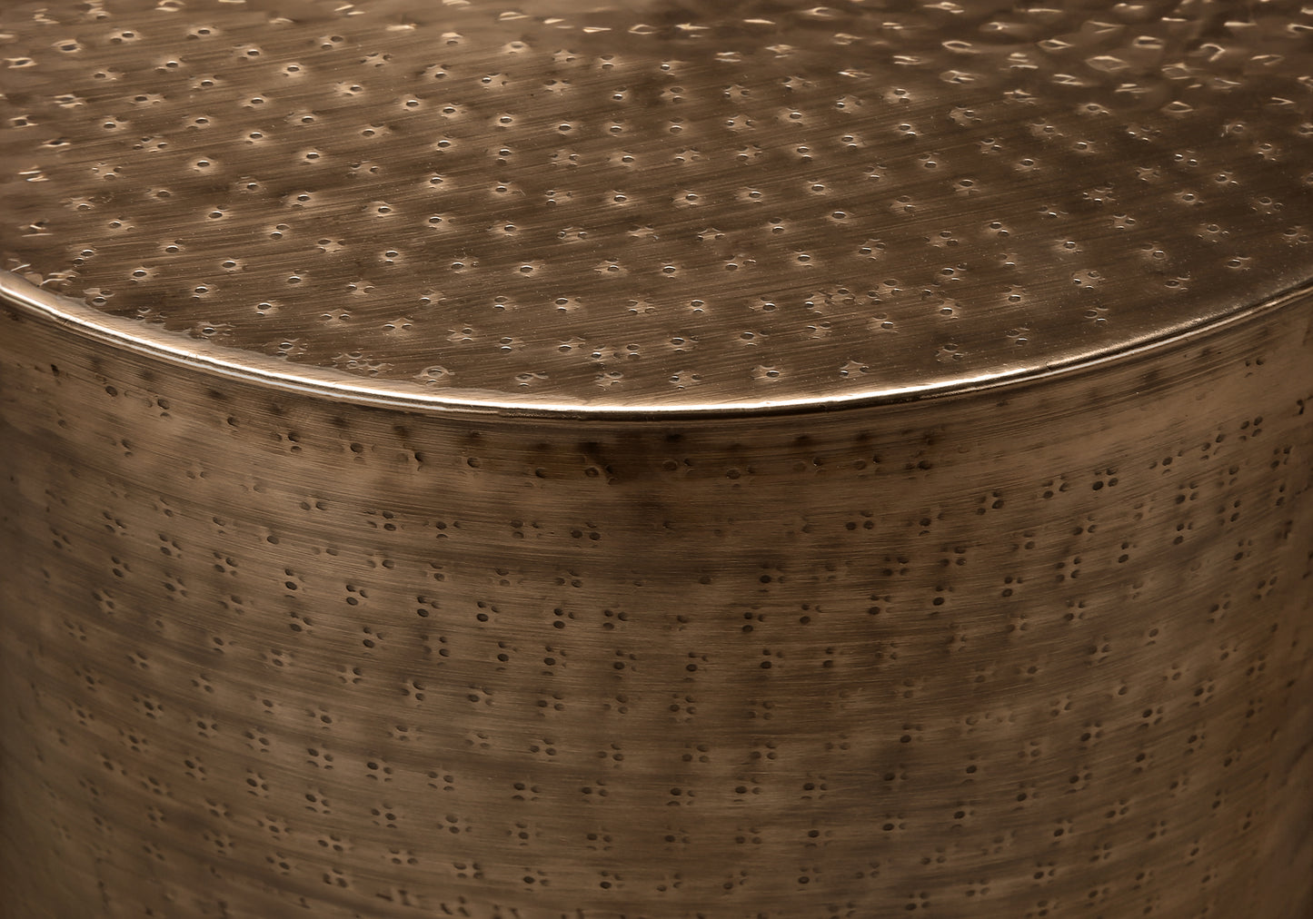Bronze hammered metal side table with a textured top surface and cylindrical body