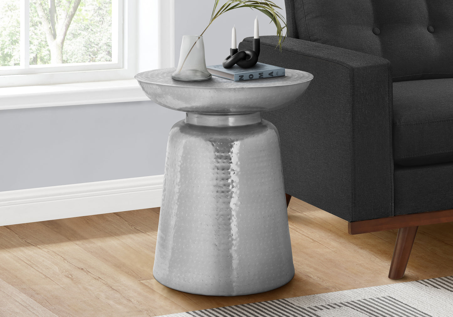 Hammered silver metal accent table with a wide rim and tapered base