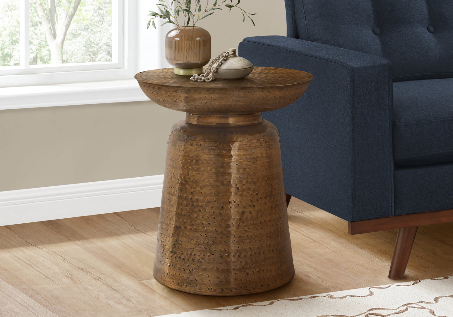 Textured antique brass drum side table with hammered finish adds rustic charm