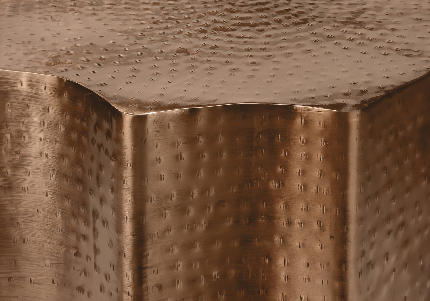 Hammered bronze side table with subtle texture and curved edges