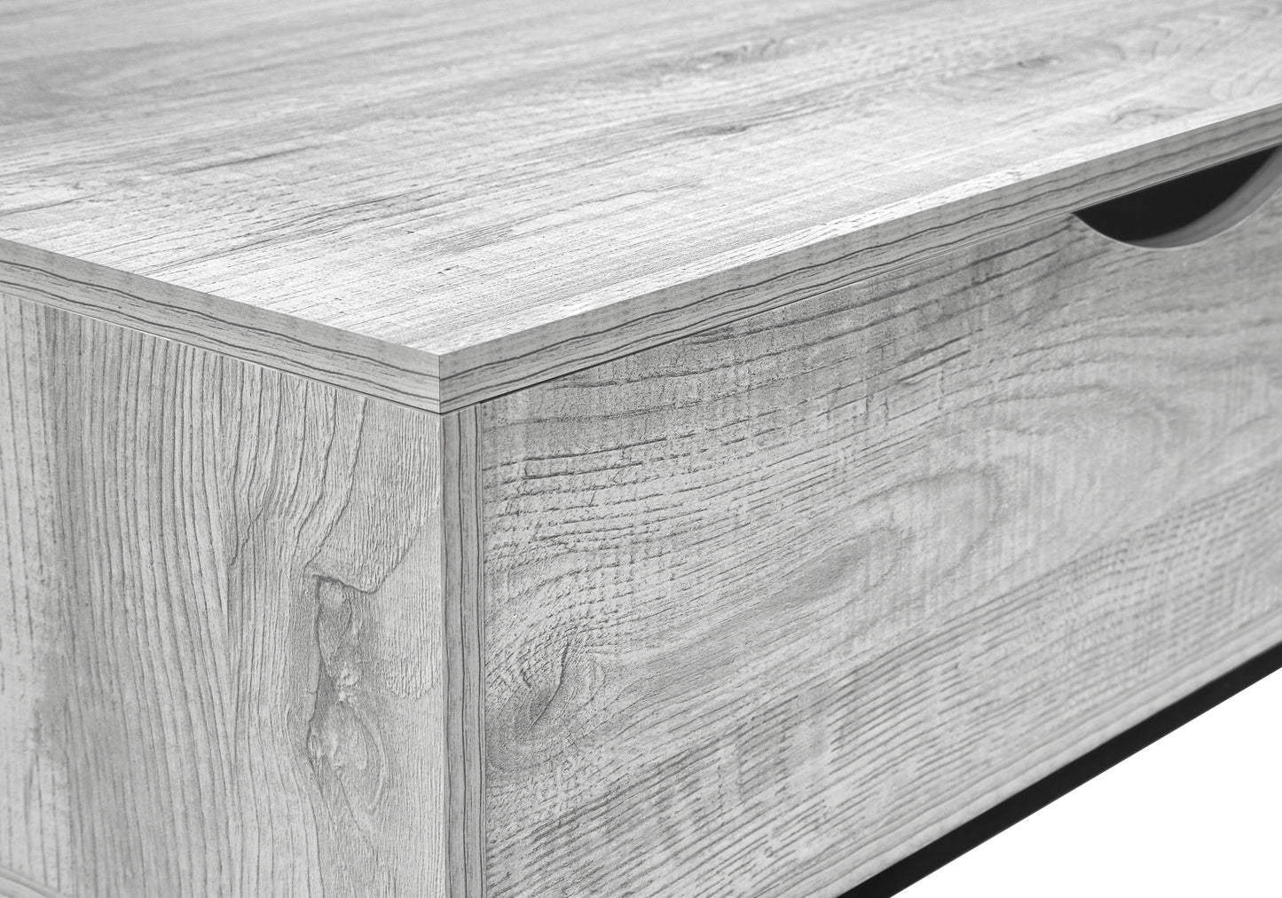 Closeup of a grey wood grain effect dresser drawer with a carved handle opening