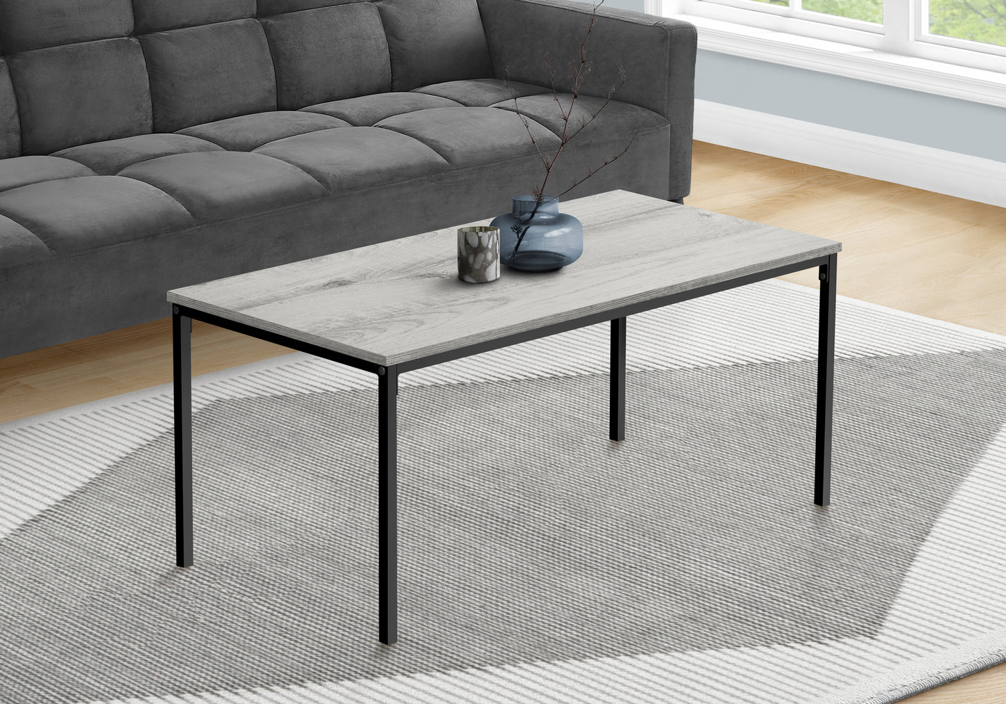 Rectangular coffee table with light grey wood grain top and black metal legs