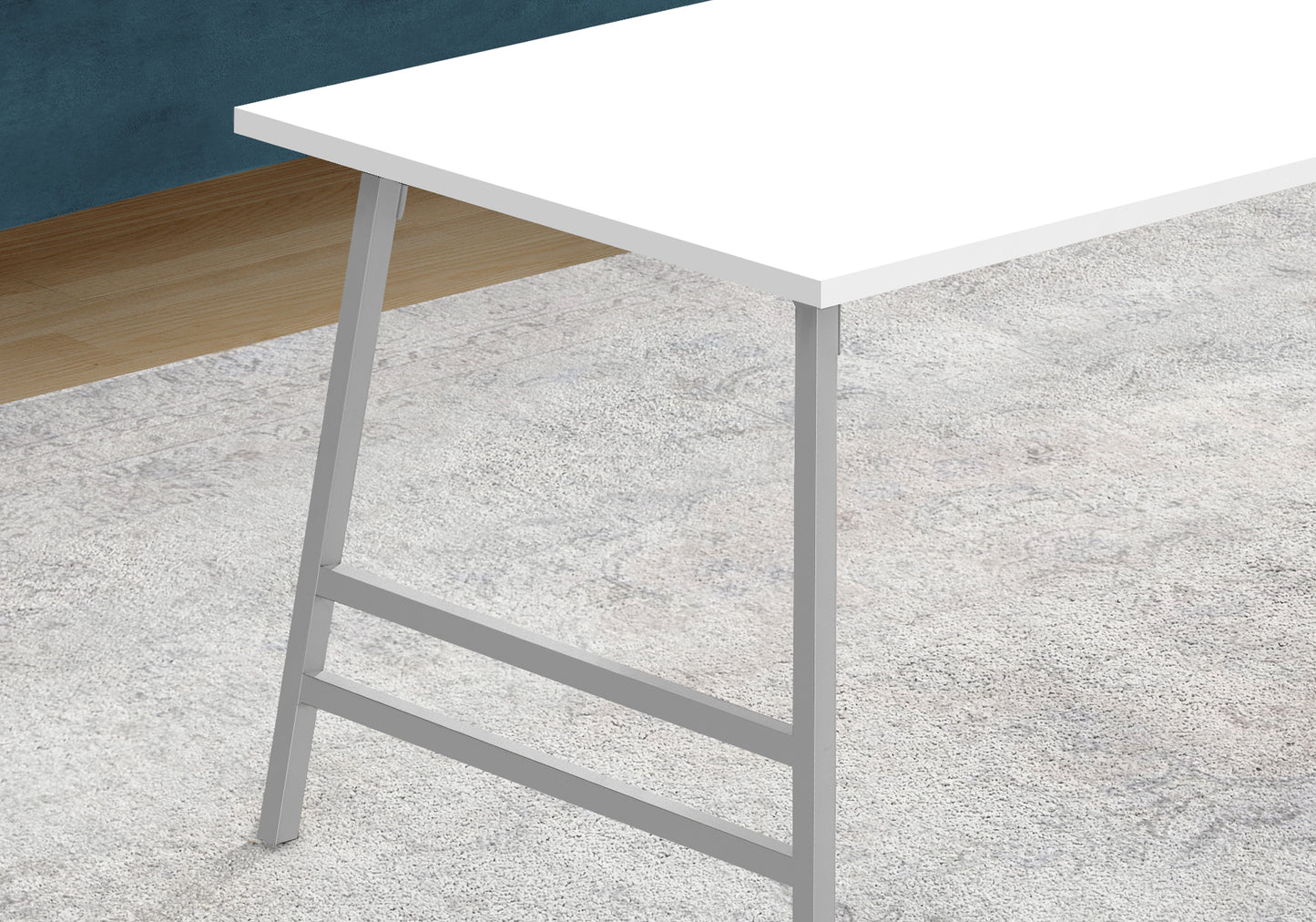 White modern desk with silver metal legs on a textured rug