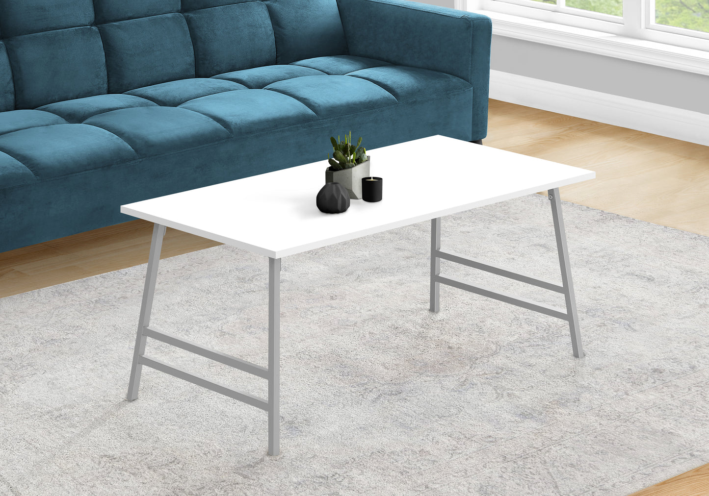 White modern coffee table with sleek grey metal legs on a light rug