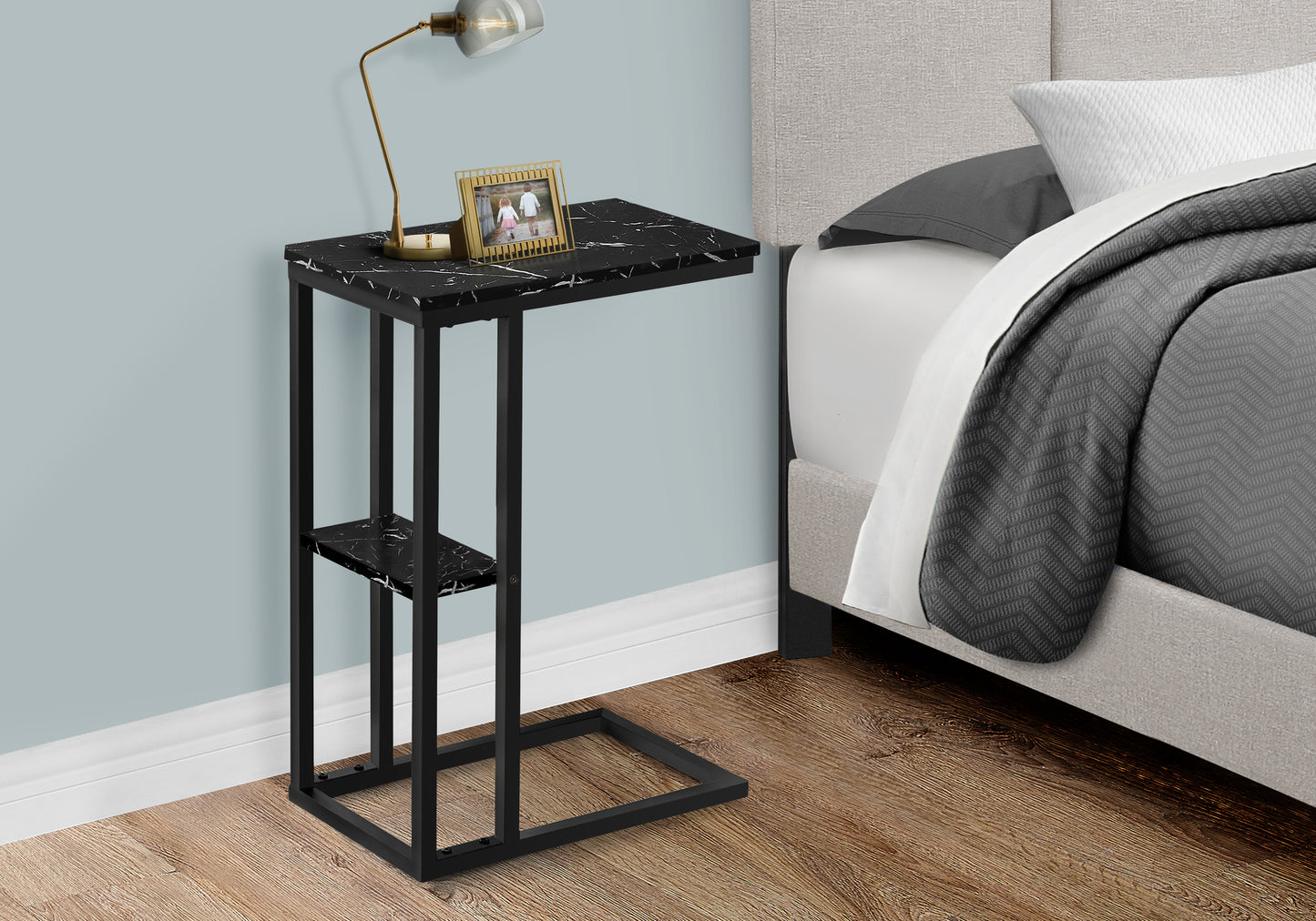 Black marble ctable with gold frame photo next to modern bedroom bed