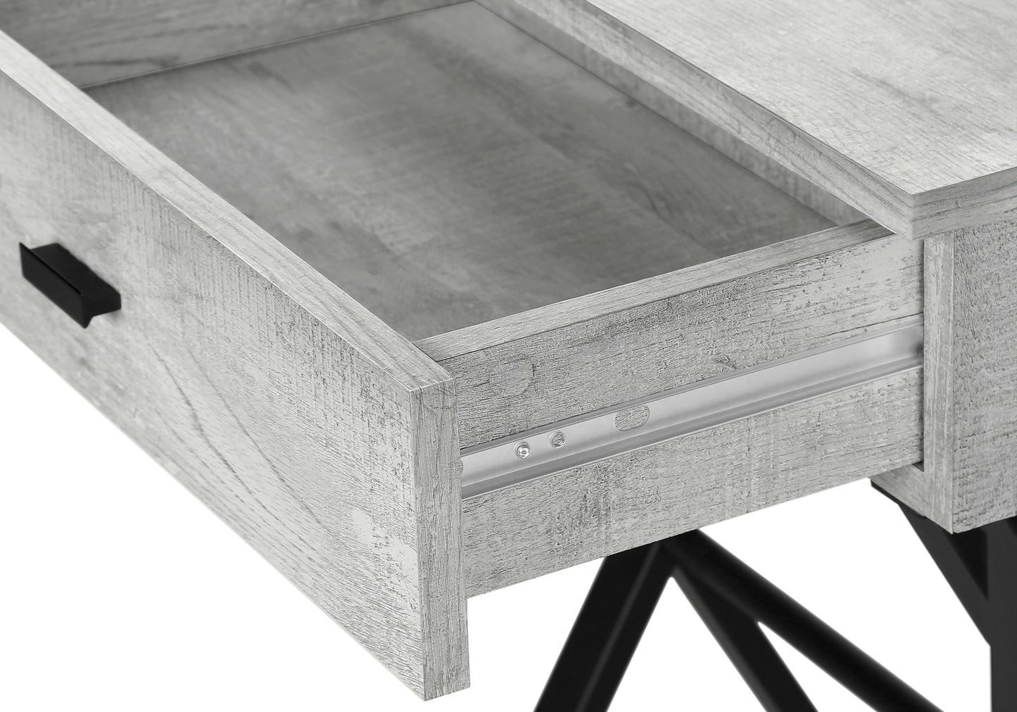 Closeup of a grey washed wood desk drawer with black handle and metal slides
