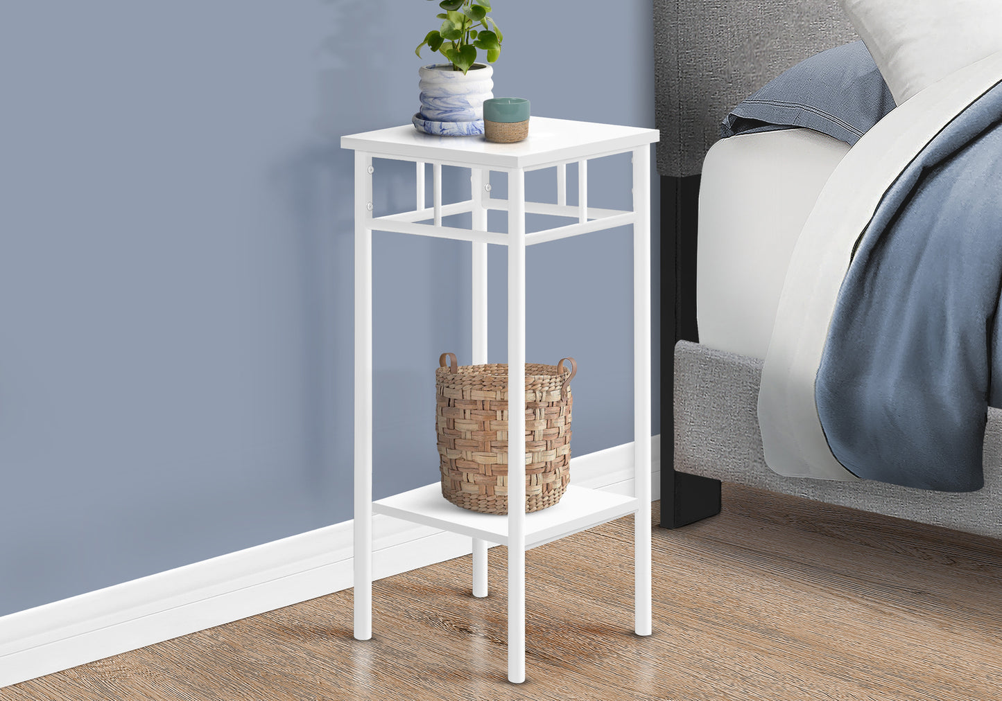 White metal accent table with two shelves beside a bed