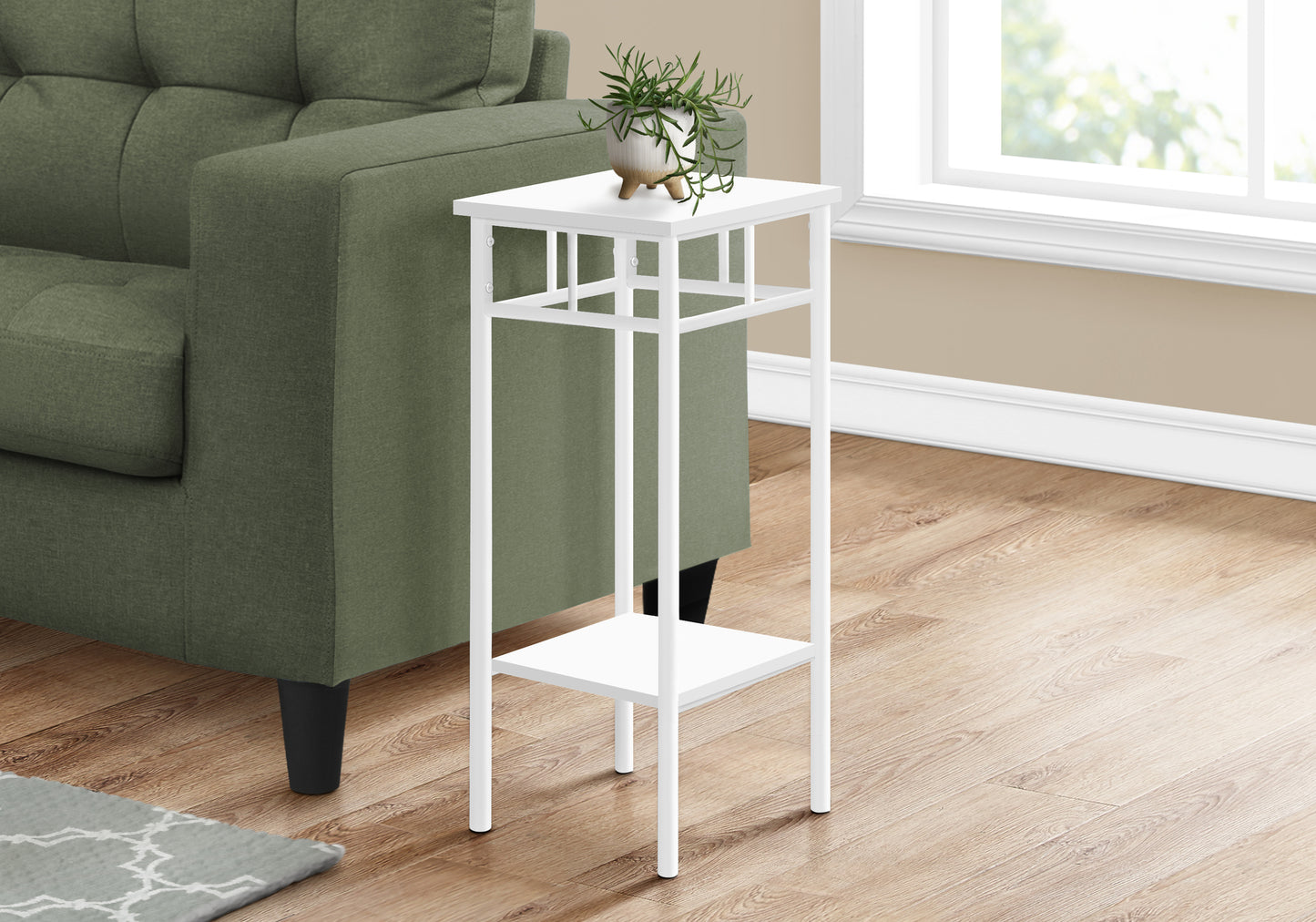 White metal end table with plant and two shelves next to green sofa