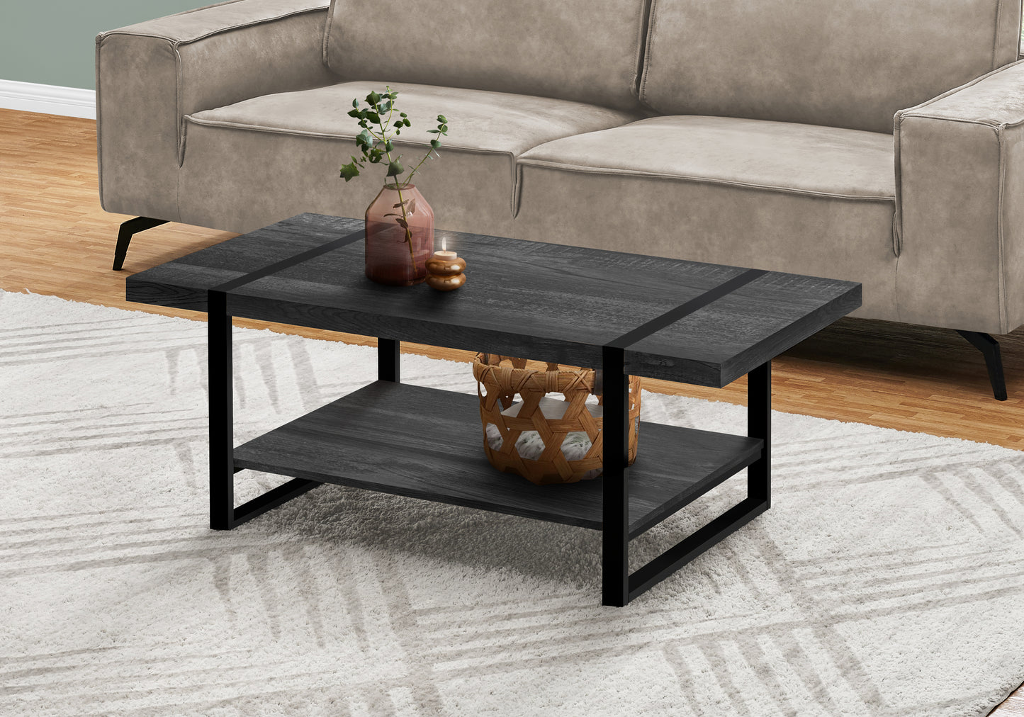 Dark wood rectangular coffee table with black metal frame and dual shelves holding decor items