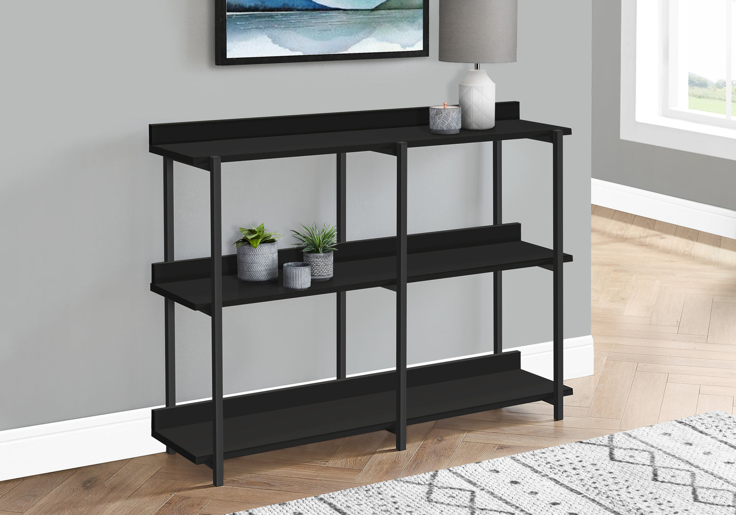 Modern black metal entryway console table with three shelves and decorative accents