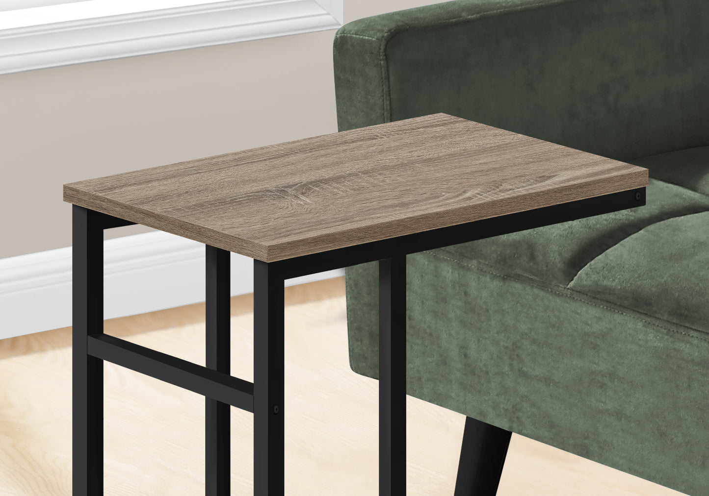 Wood grain Ctable with black metal frame nestled by armchair