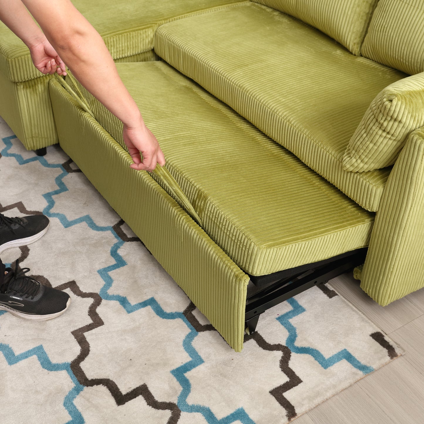 Light green corduroy sofa with pullout bed mechanism on display